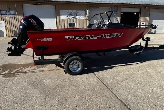 2026 Tracker Pro Guide V-175 WT boat in red on a trailer, parked outdoors.