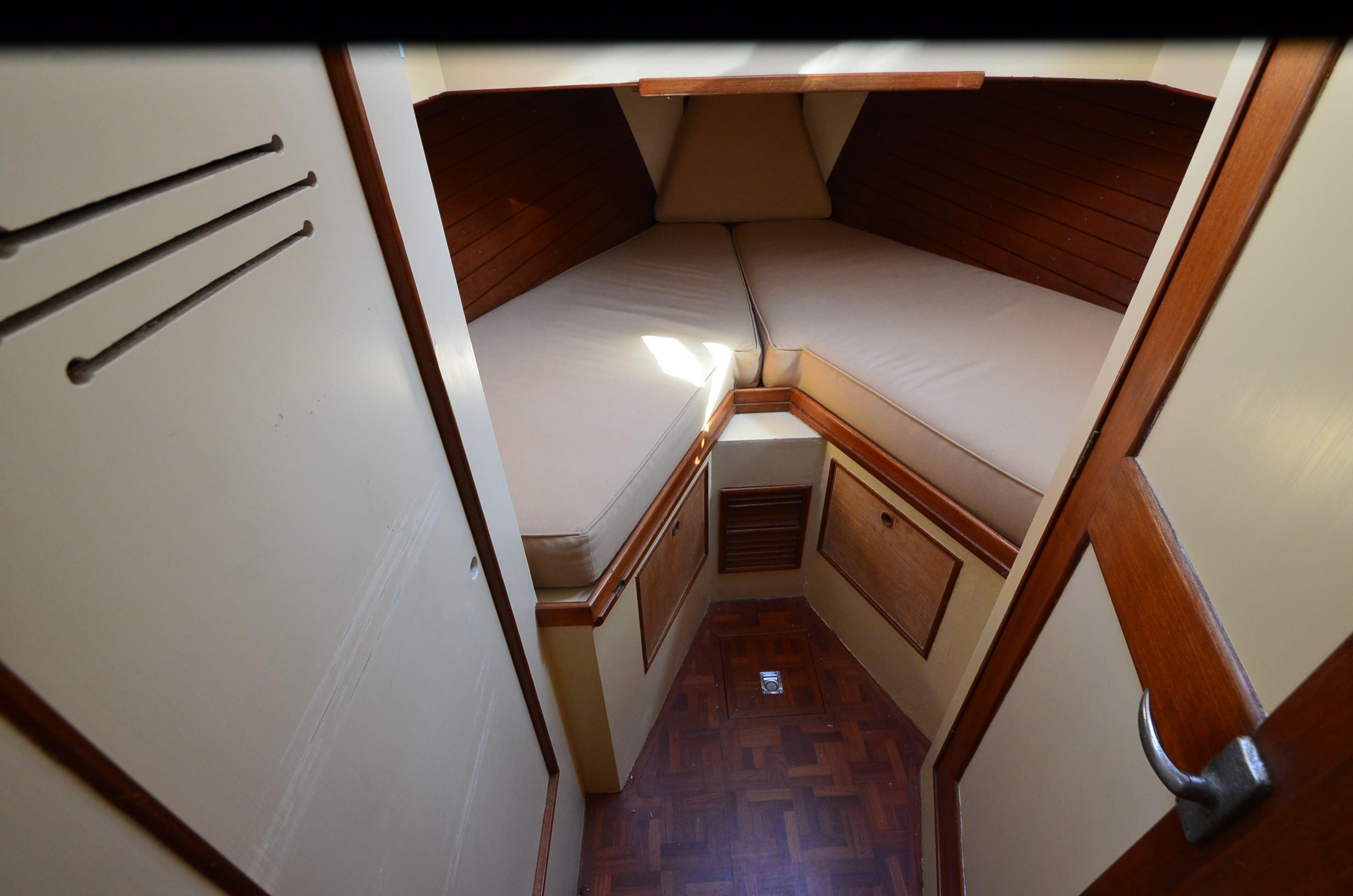 1977 Grand Banks GB 32 cabin interior with V-berth and wooden accents.