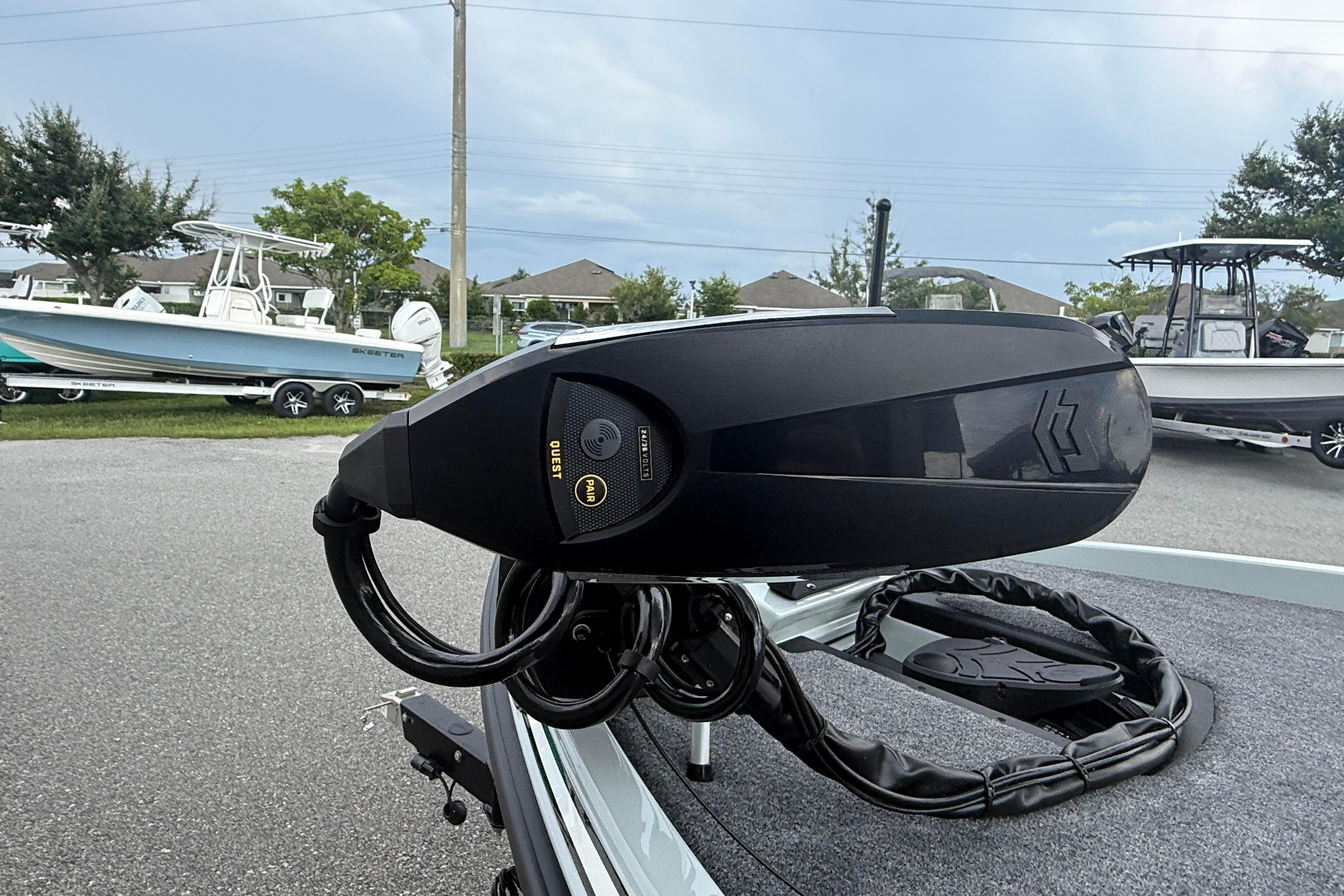 Trolling motor on a 2027 Phoenix 921 Elite X II boat, parked near other boats.