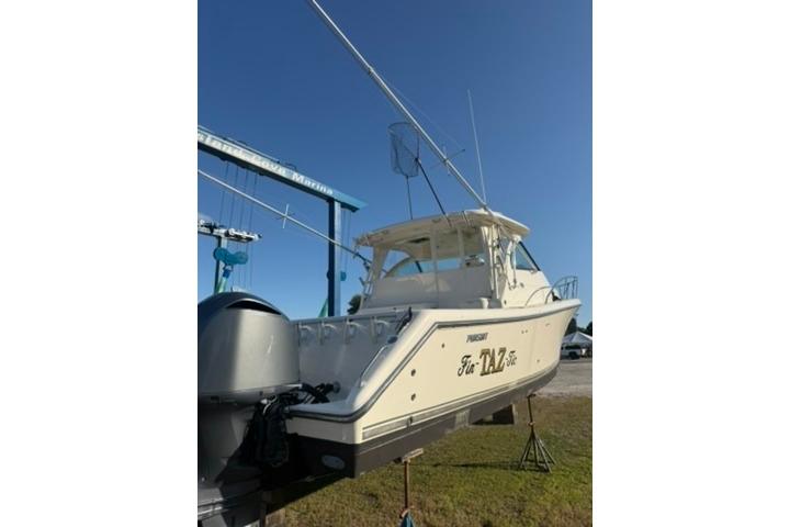 2010 Pursuit OS 375 Offshore boat on dry dock under clear blue sky.