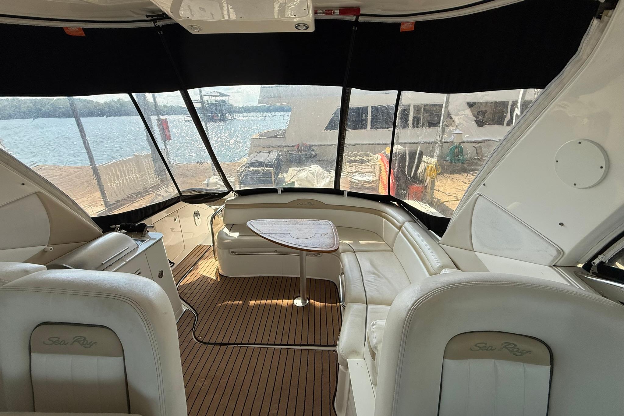 Interior of a 2009 Sea Ray 350 Sundancer yacht with white seating and wood flooring.