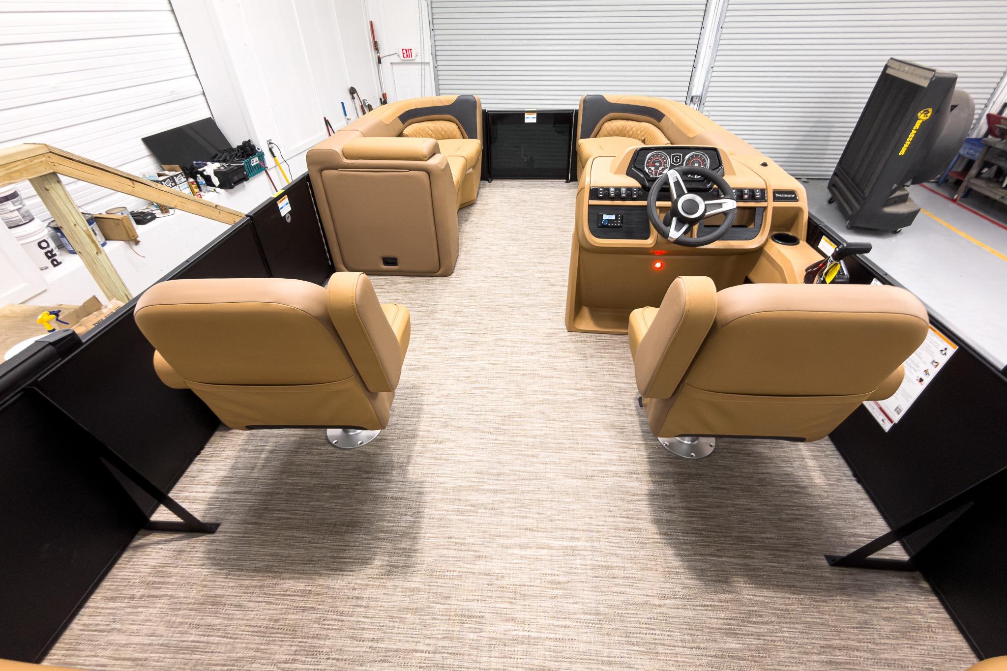Interior of 2026 Godfrey Sweetwater 22' Tritoon with tan seating and modern dashboard.