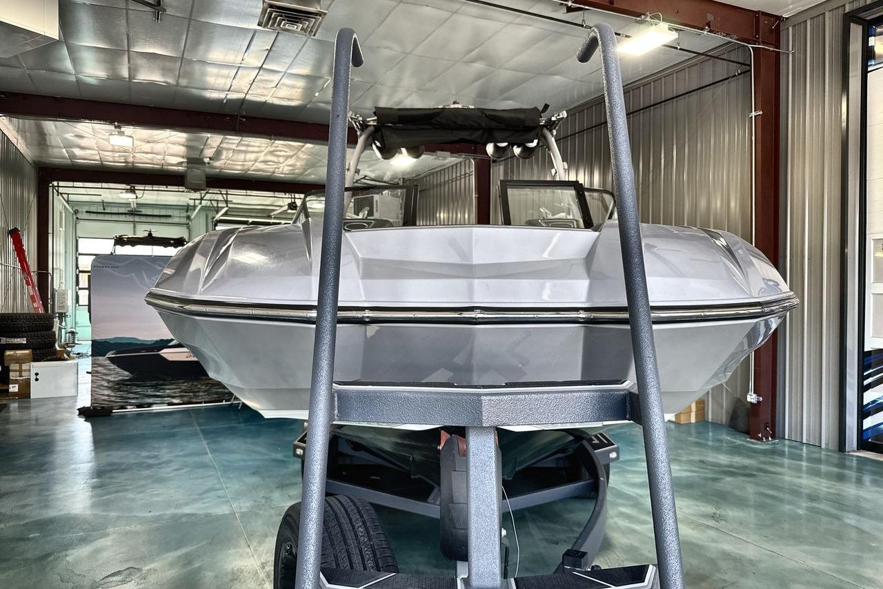 2021 Supra SE 550 boat in a garage, front view with trailer.