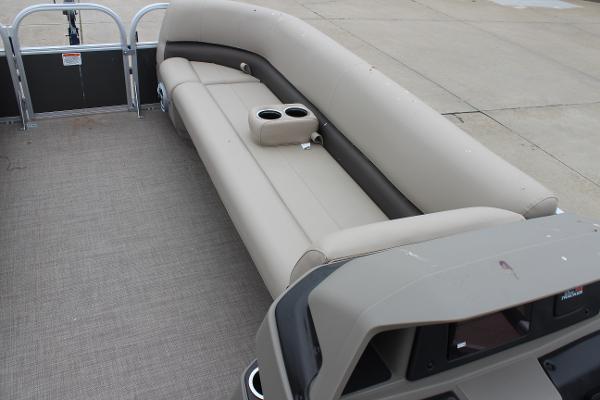 2025 Sun Tracker Party Barge 18 DLX interior with beige seating and cup holders.
