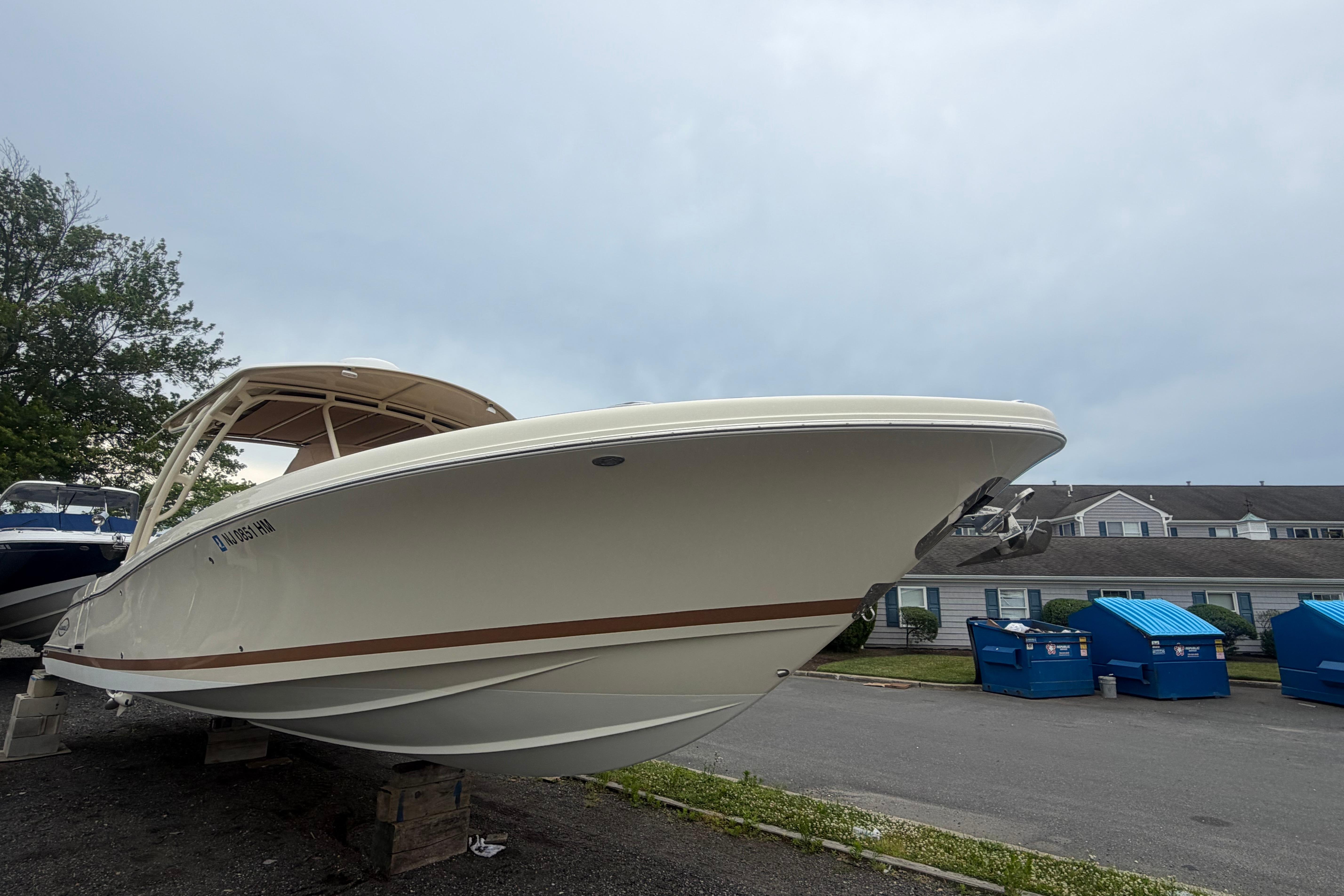 2017 Chris-Craft Catalina 34 boat on land, overcast sky background.