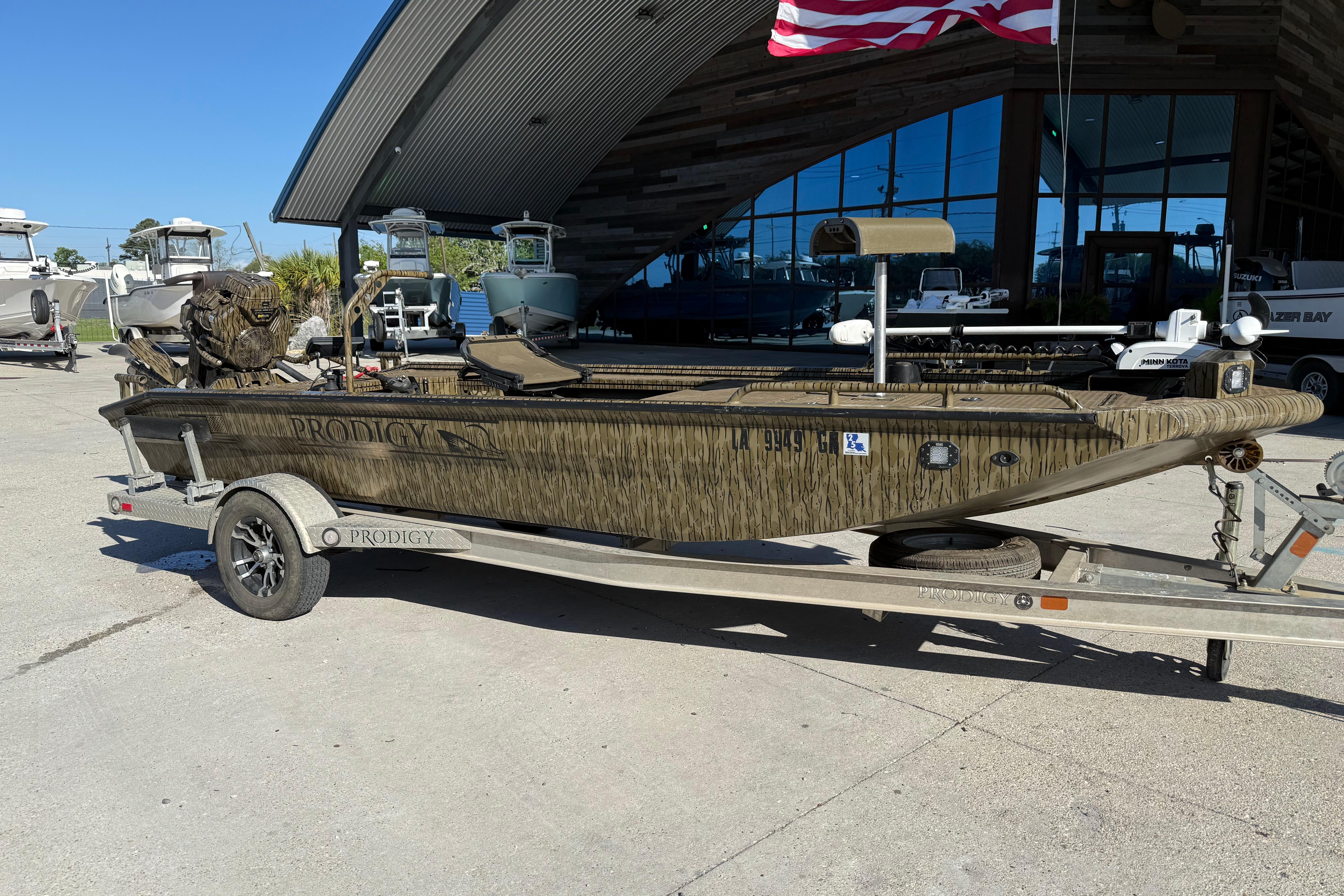 2022 Prodigy 1854 boat on trailer outside a showroom with American flag.