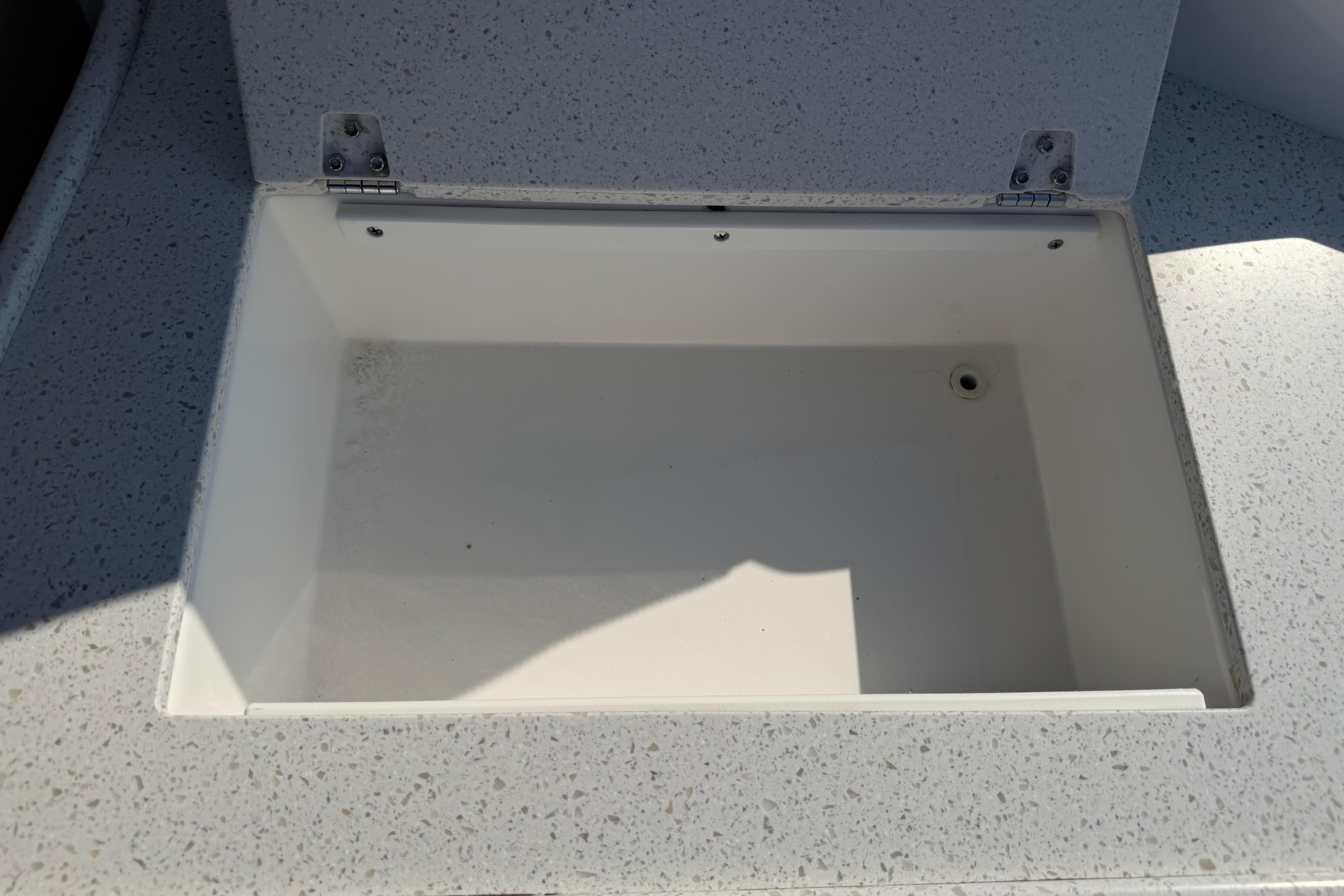 Open storage compartment on a 2019 Rinker EX 320 boat.