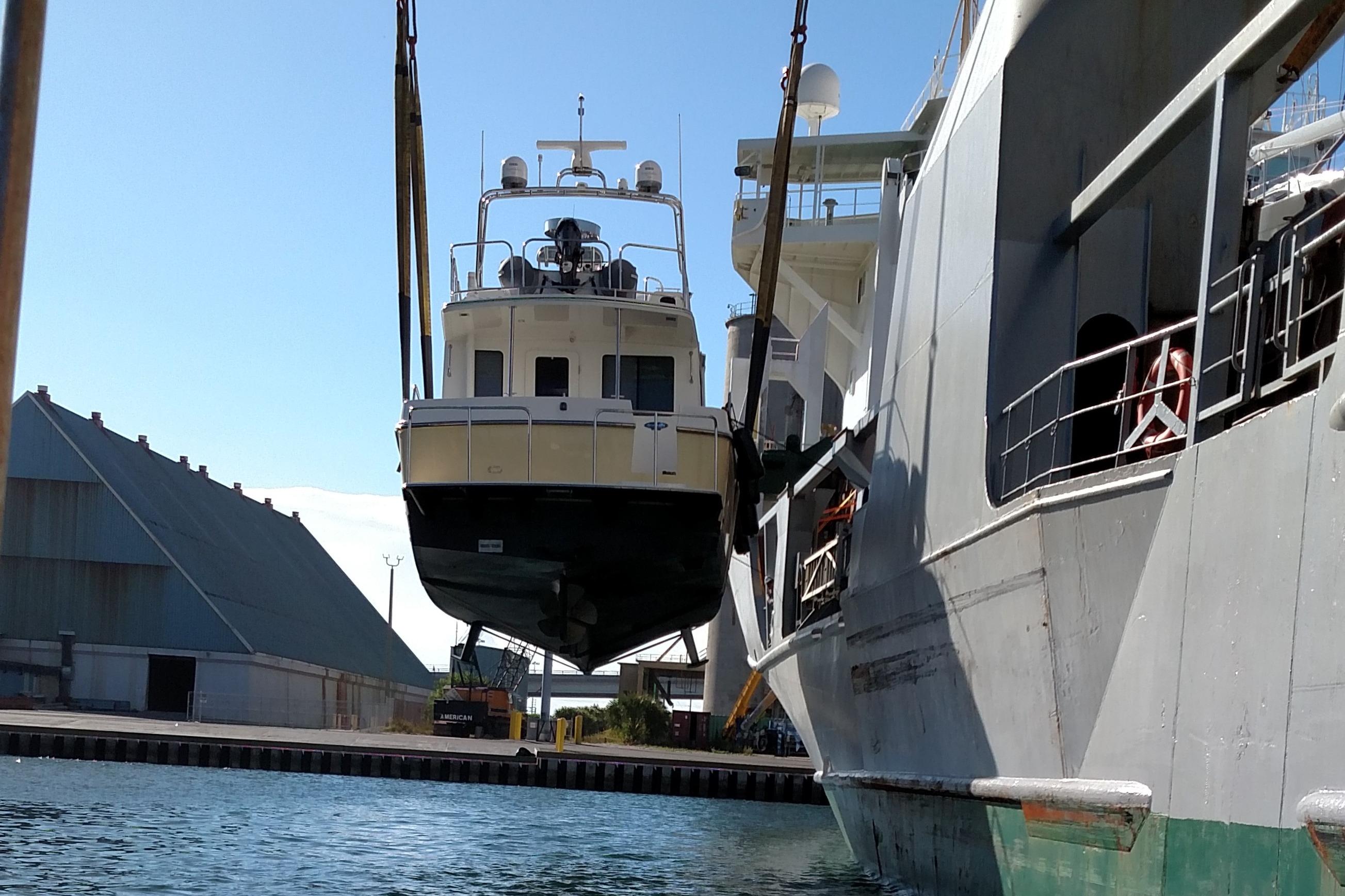 American Tug 435, 2015 model, being lifted by crane at a shipyard.