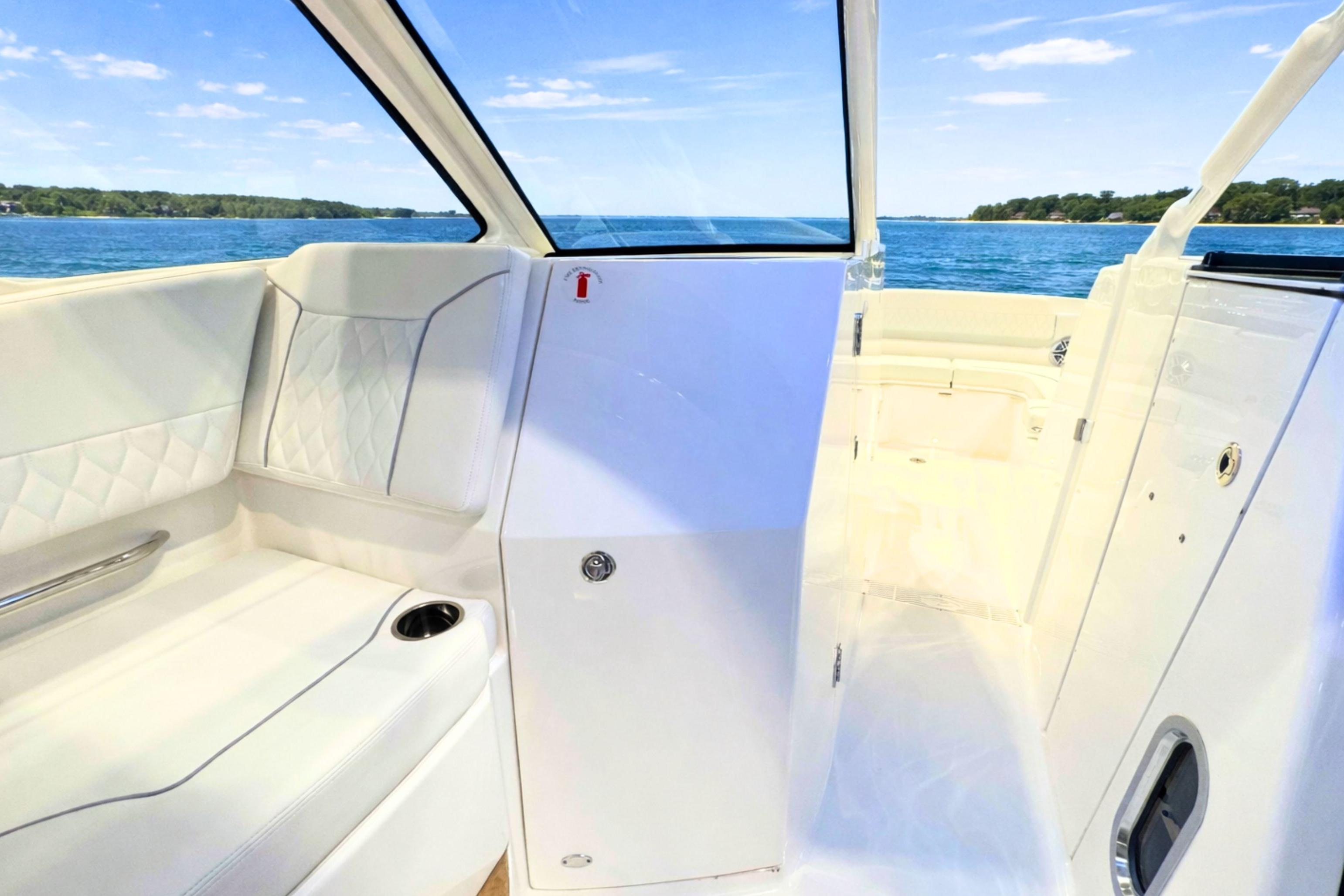 2026 Pursuit DC 365 Dual Console interior with white seating, ocean view, and sleek design.