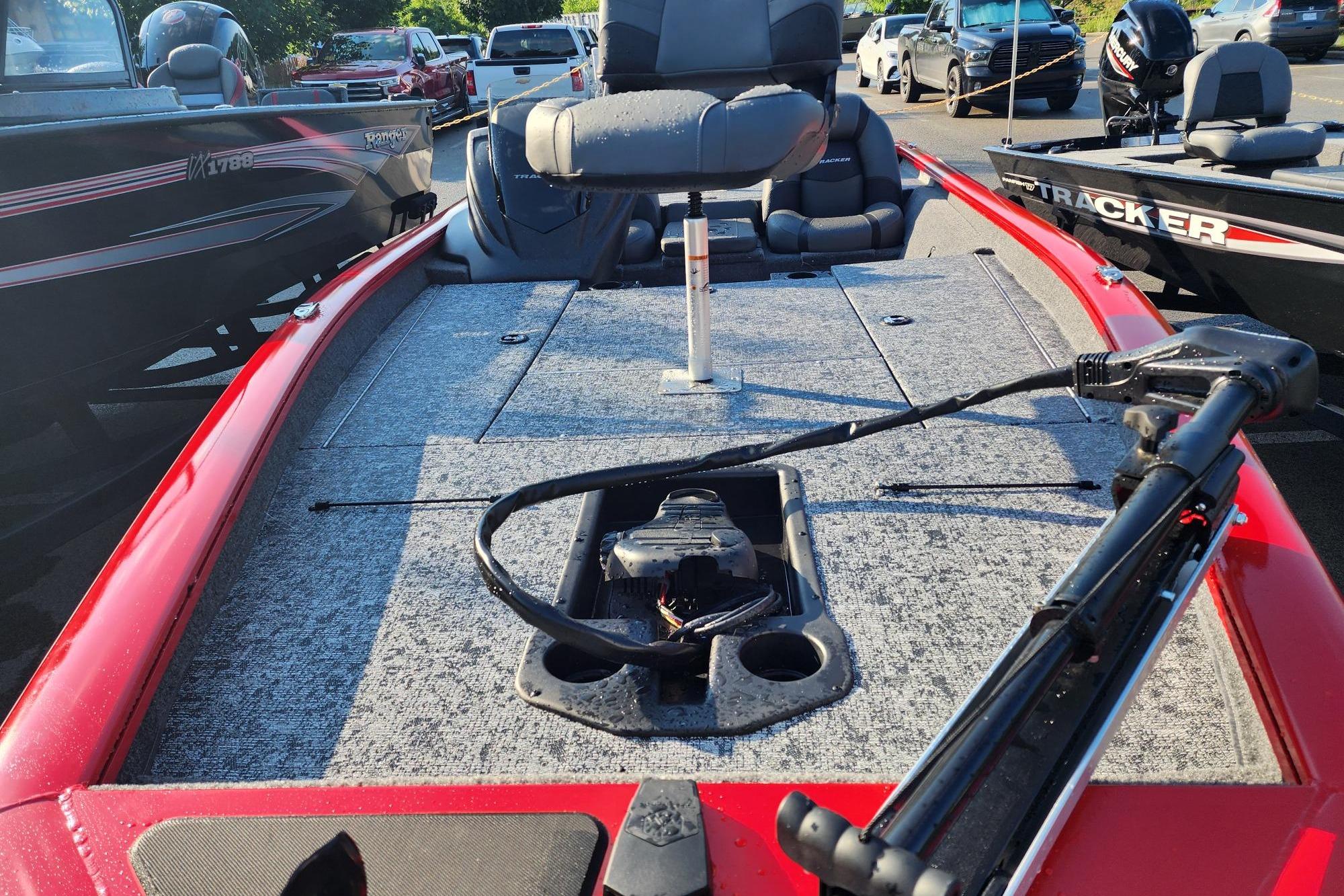 2026 Tracker Pro Team 190 boat with red exterior and fishing deck, parked outdoors.