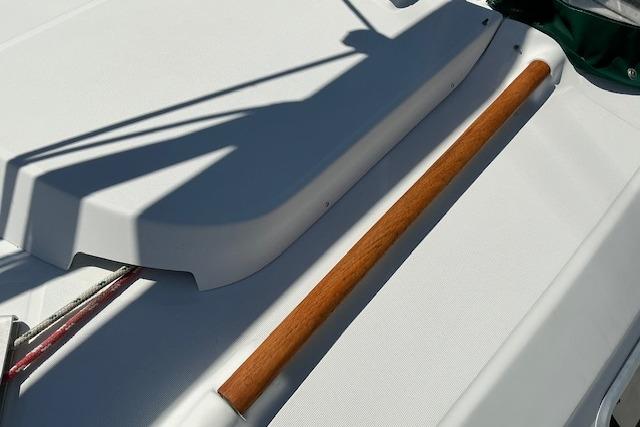 Deck of 2000 Beneteau Oceanis 321 sailboat with wooden handrail detail.