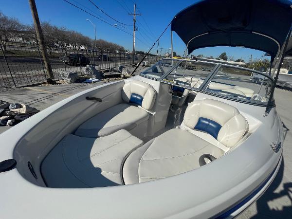 2012 Tahoe Q4 SS boat with white and blue interior, docked under clear blue sky.