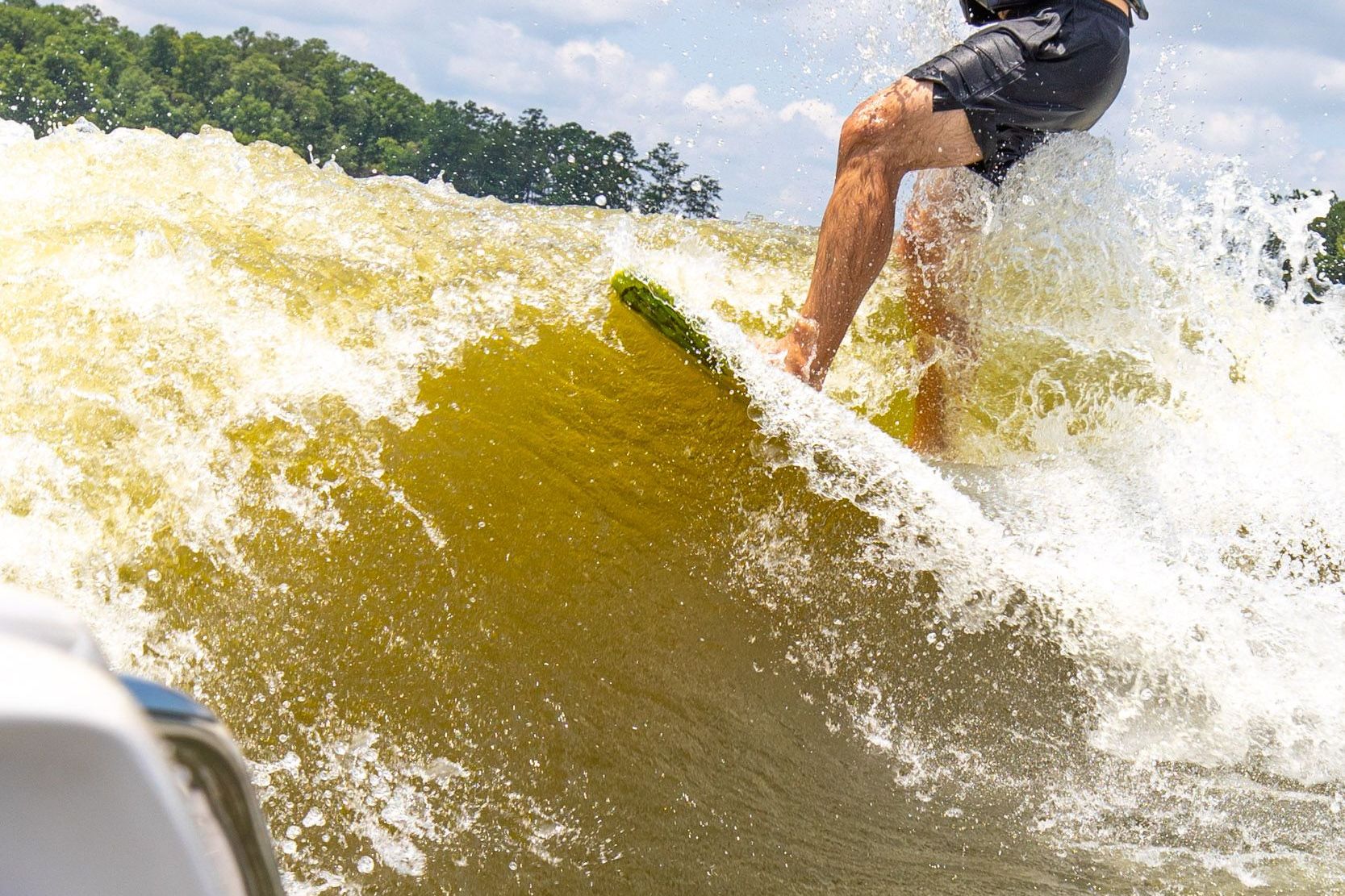 Surfer riding wave behind 2008 Nautique Super Air Nautique 220.