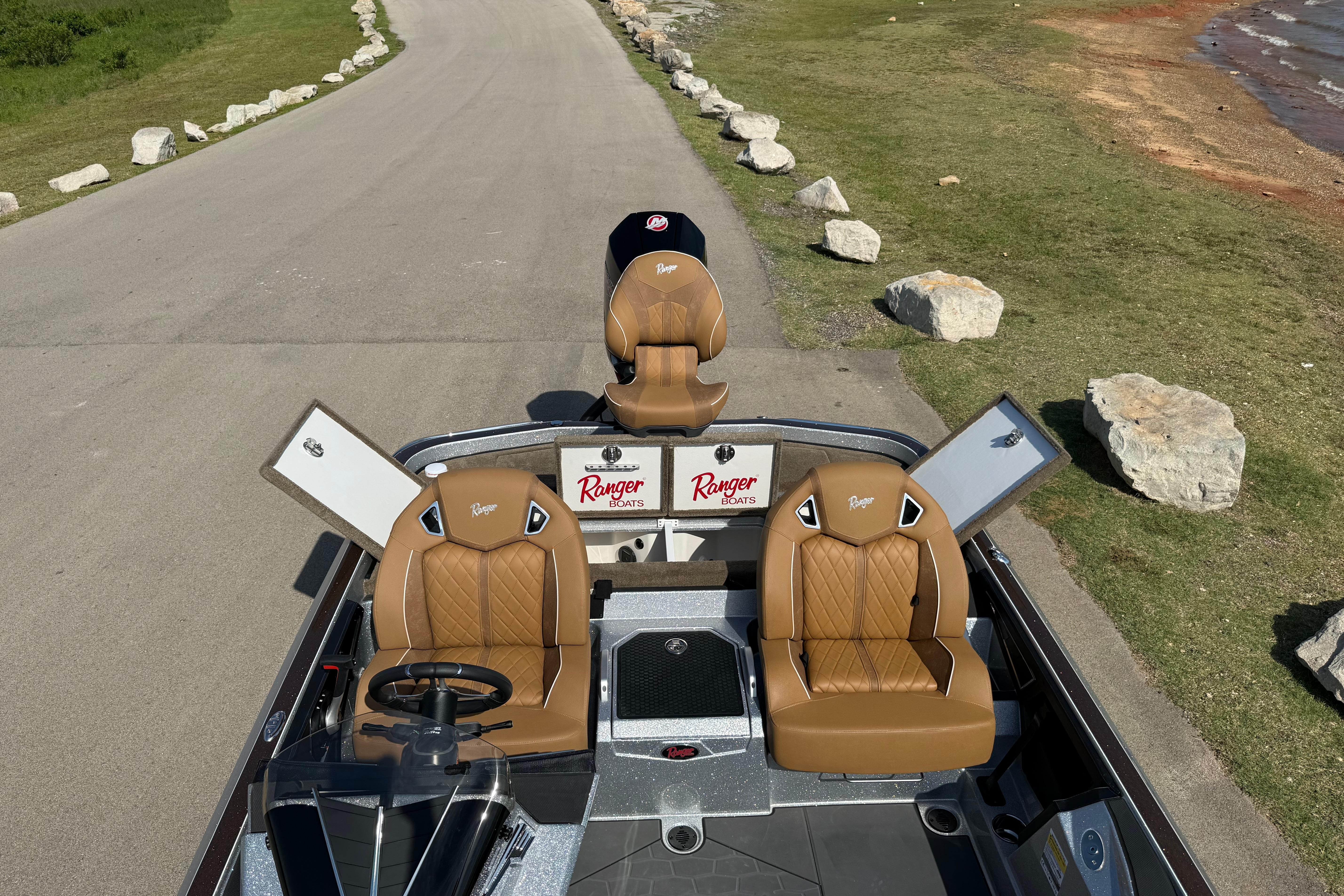 2026 Ranger Z521R boat with tan seats, open compartments, and scenic lakeside view.