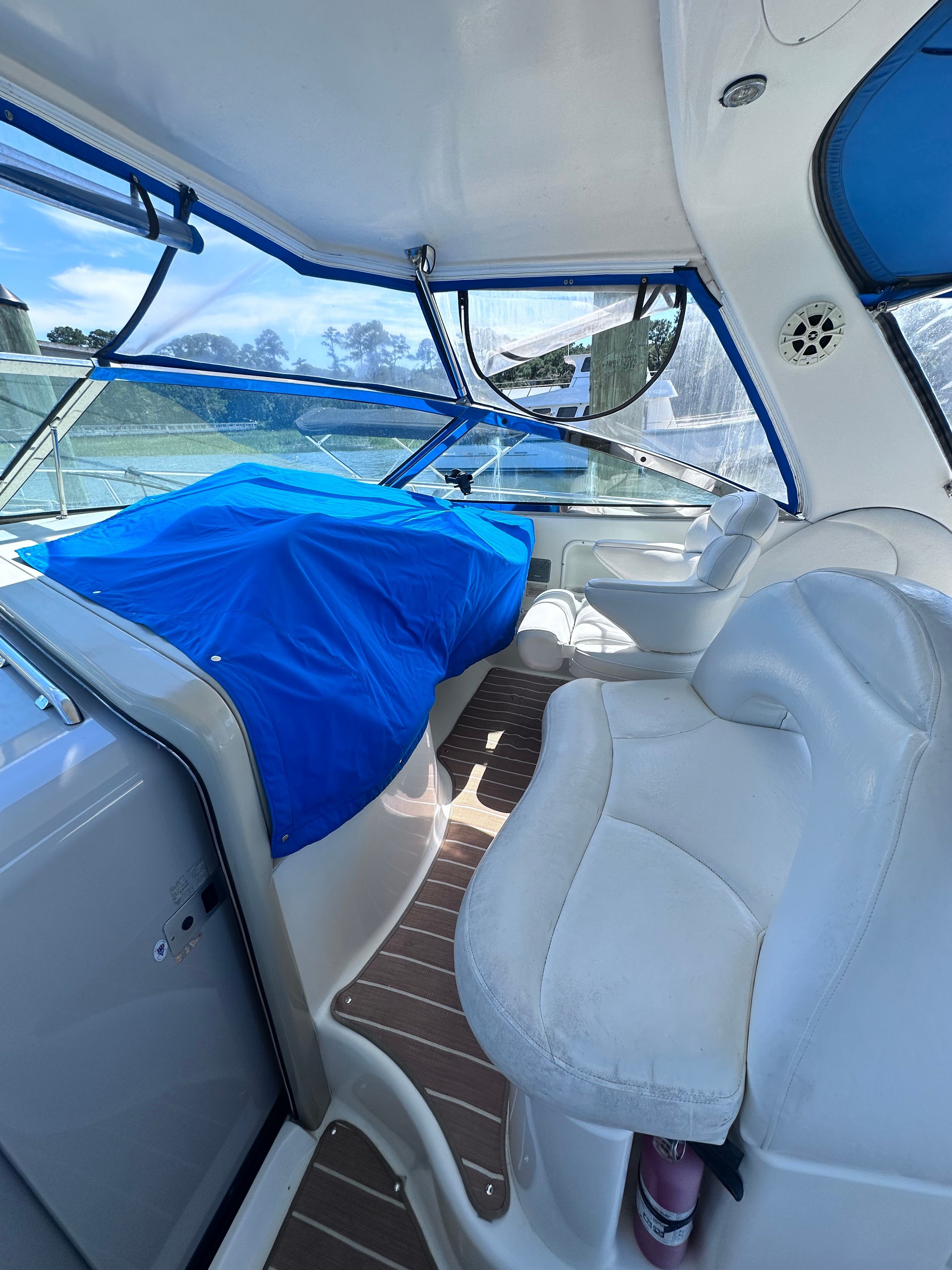 Interior of 2000 Sea Ray 380 Sundancer with blue cover and white seating.