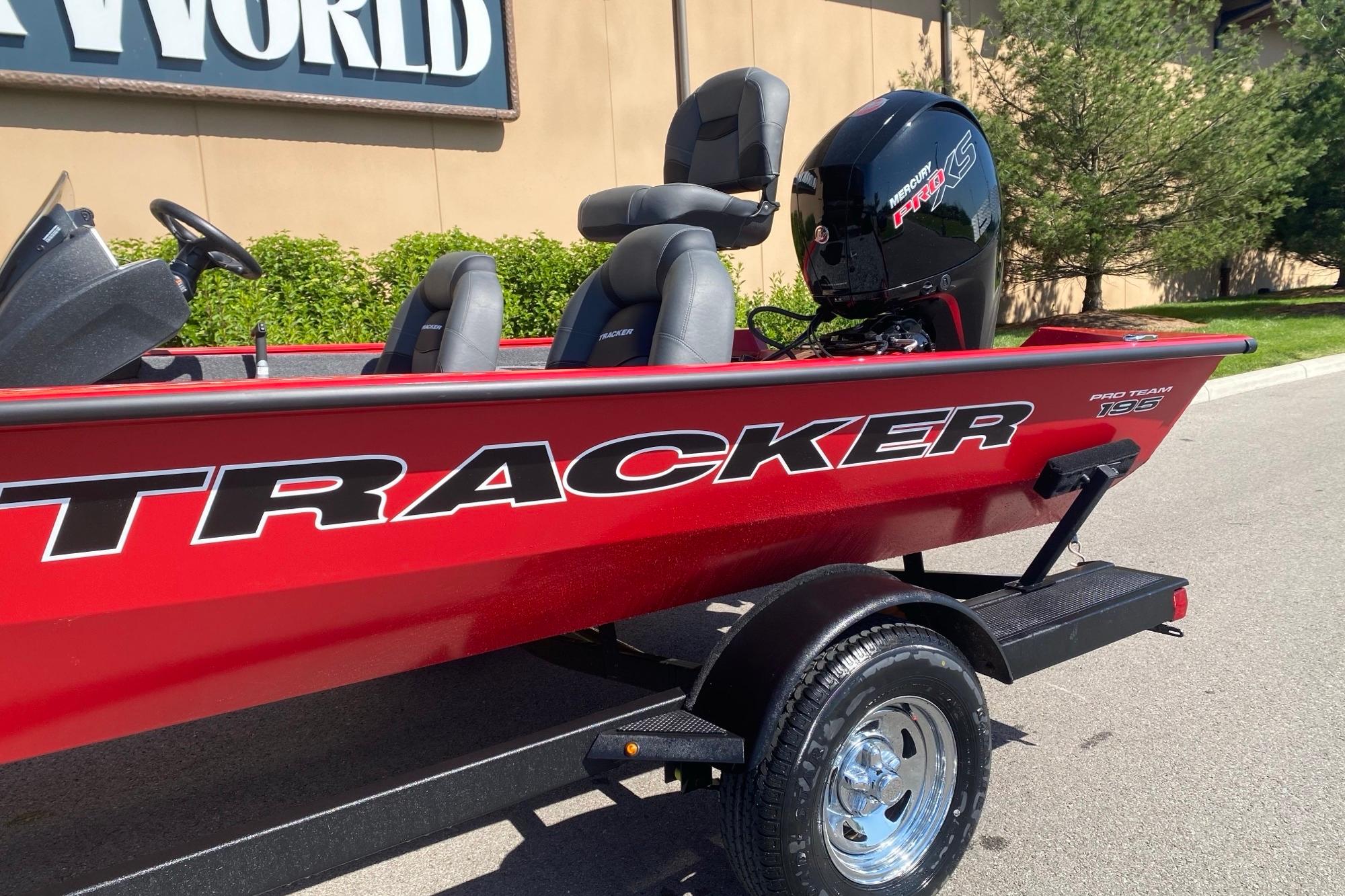 Red 2026 Tracker Pro Team 195 boat with Mercury engine, parked outdoors.
