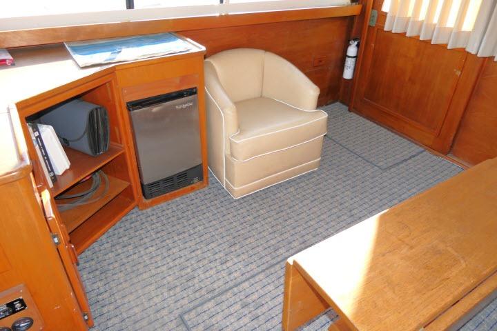 Interior of 1988 Jersey 36 Convertible Sportfisher with chair, mini-fridge, and wooden cabinetry.