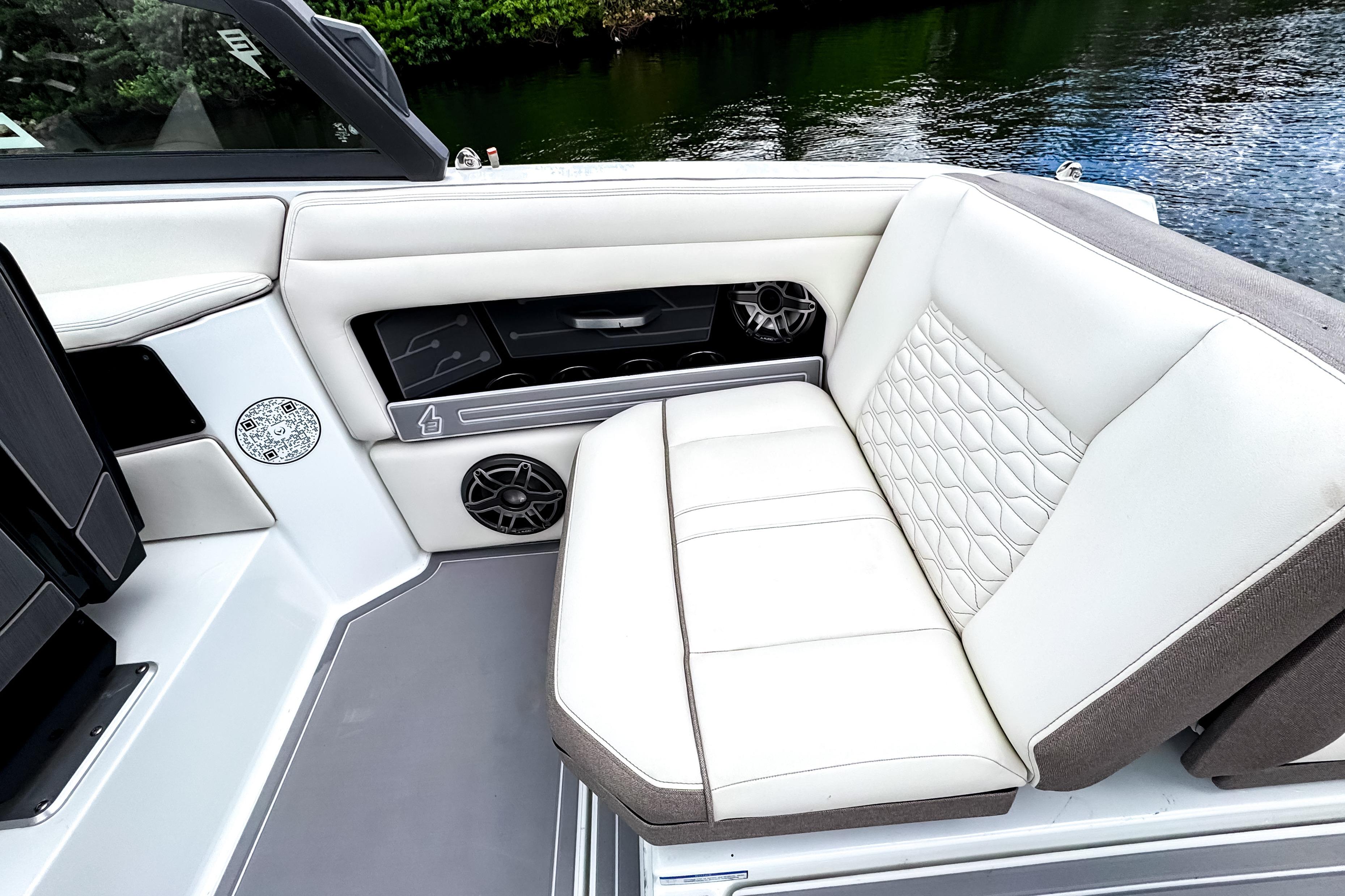 Luxurious seating on 2026 Ingenity EL boat with quilted upholstery and integrated speakers.