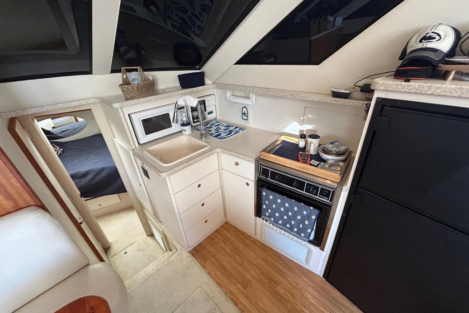 Compact kitchen area in a 2000 Silverton 352 Motor Yacht with modern amenities.