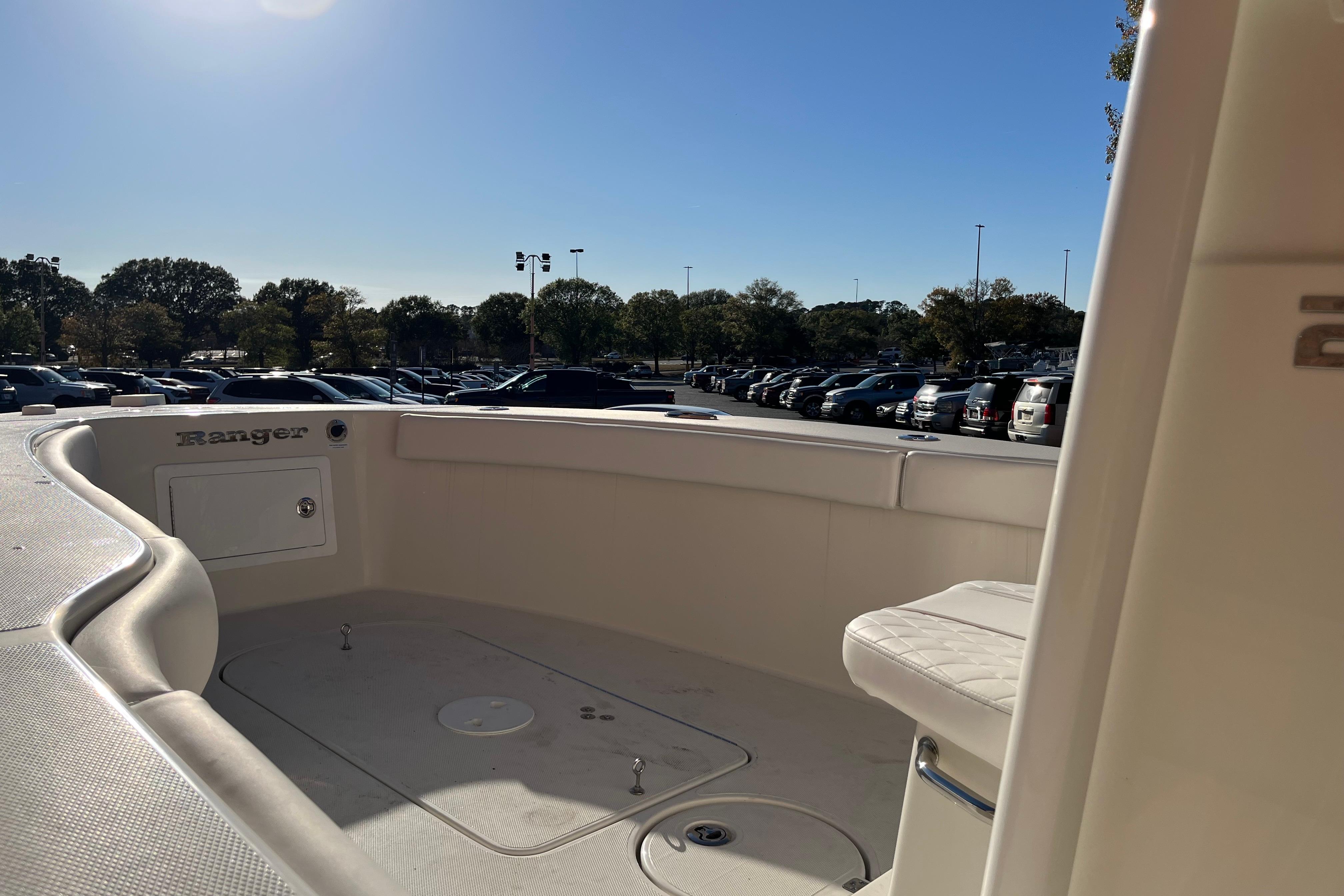2024 Ranger 2600 Bay boat interior with seating, parked outdoors under clear sky.