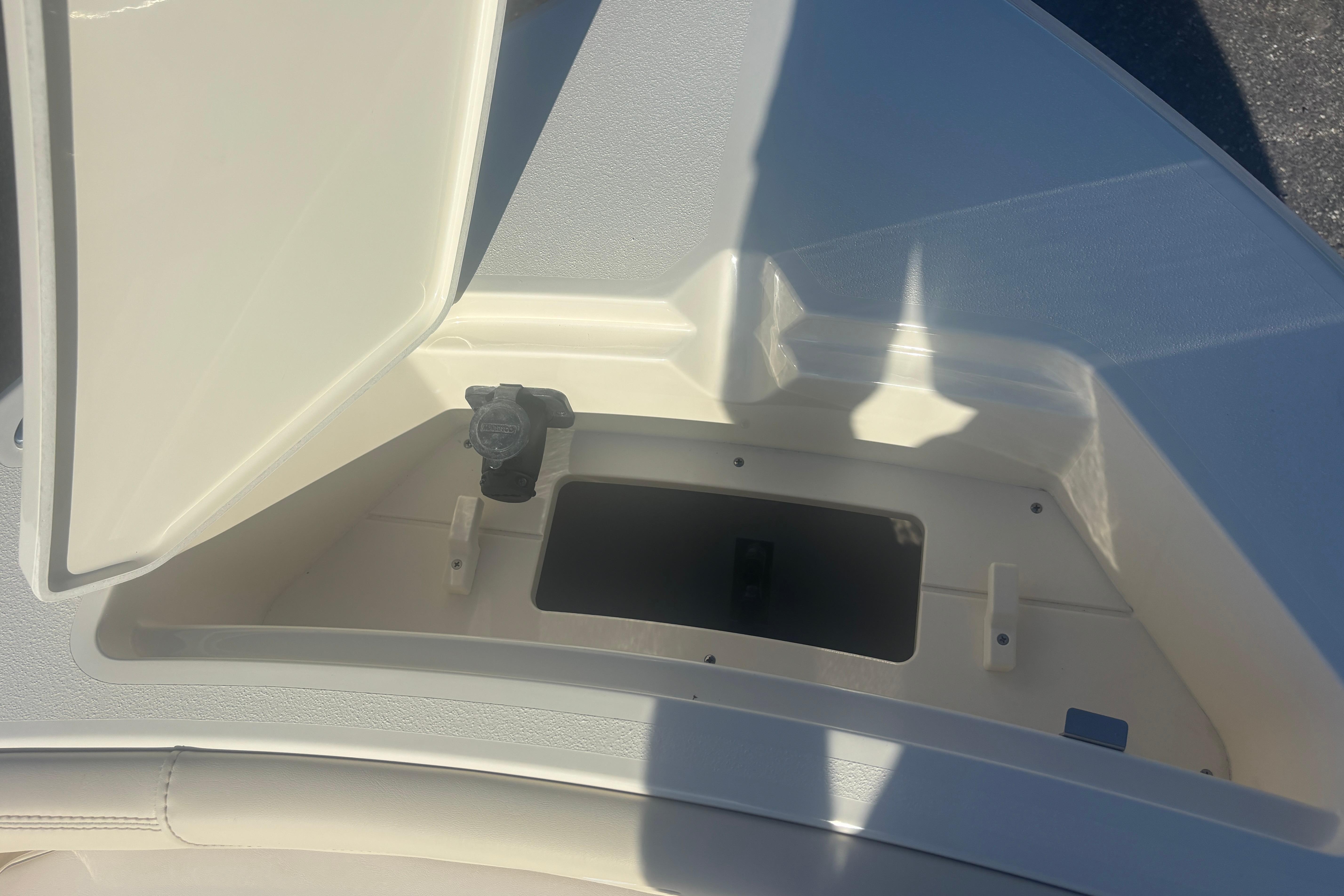 Open storage compartment on 2026 Scout 188 Sportfish boat, showcasing interior space.