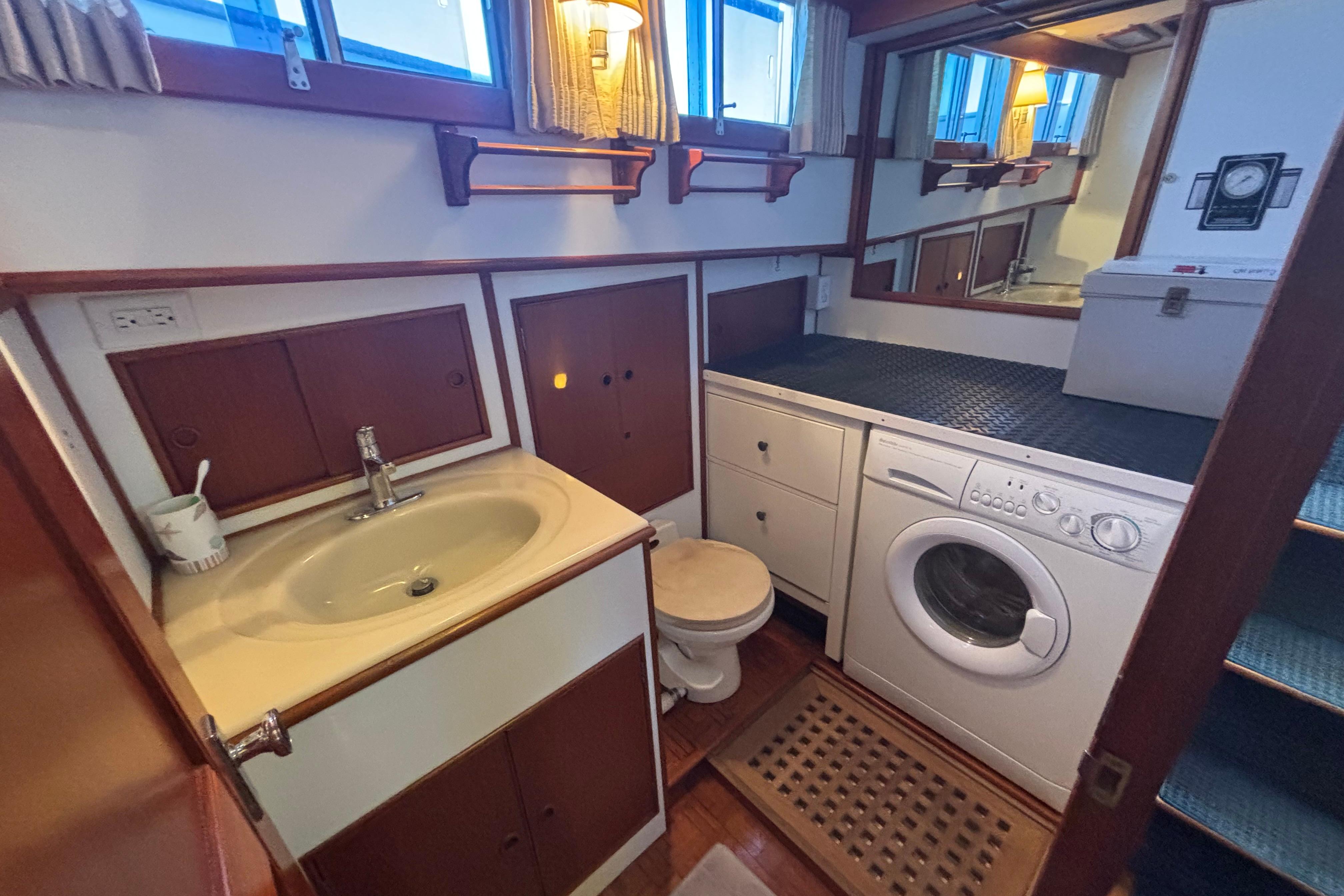 Laundry area with sink and washing machine on 1989 Grand Banks 46 Classic yacht.
