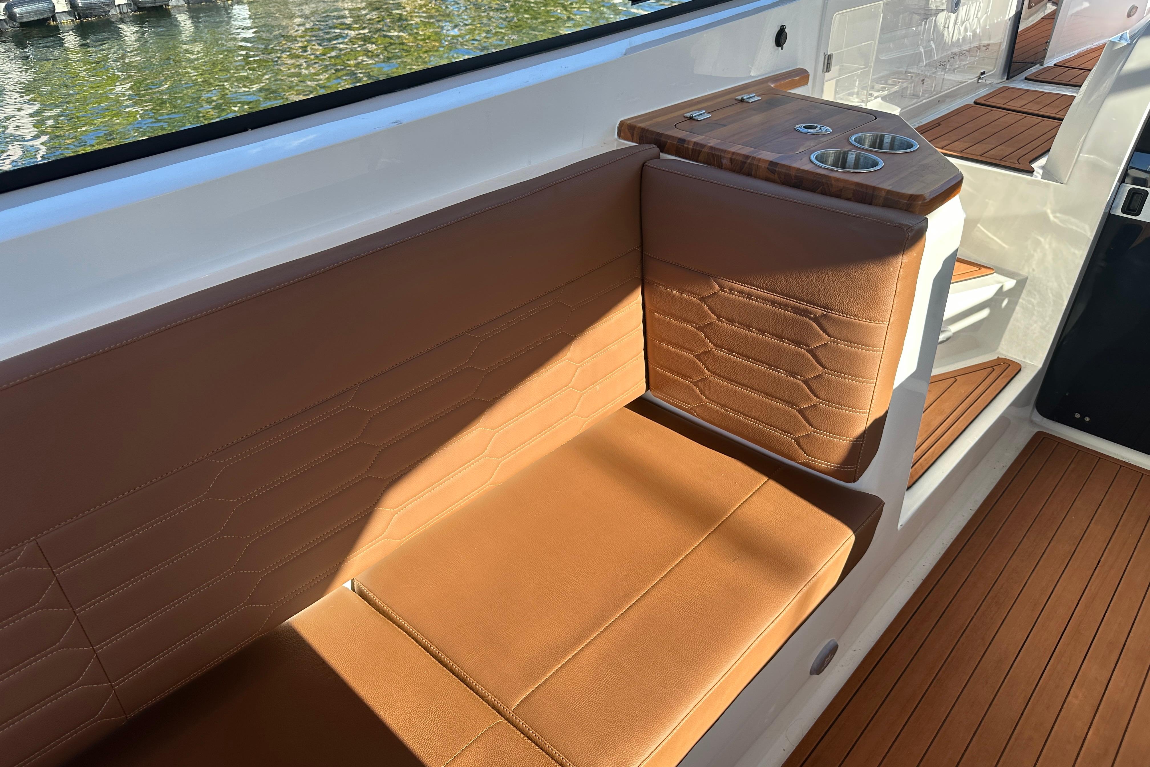 Luxurious seating on 2025 NX Boats 370 with elegant brown upholstery and cup holders.