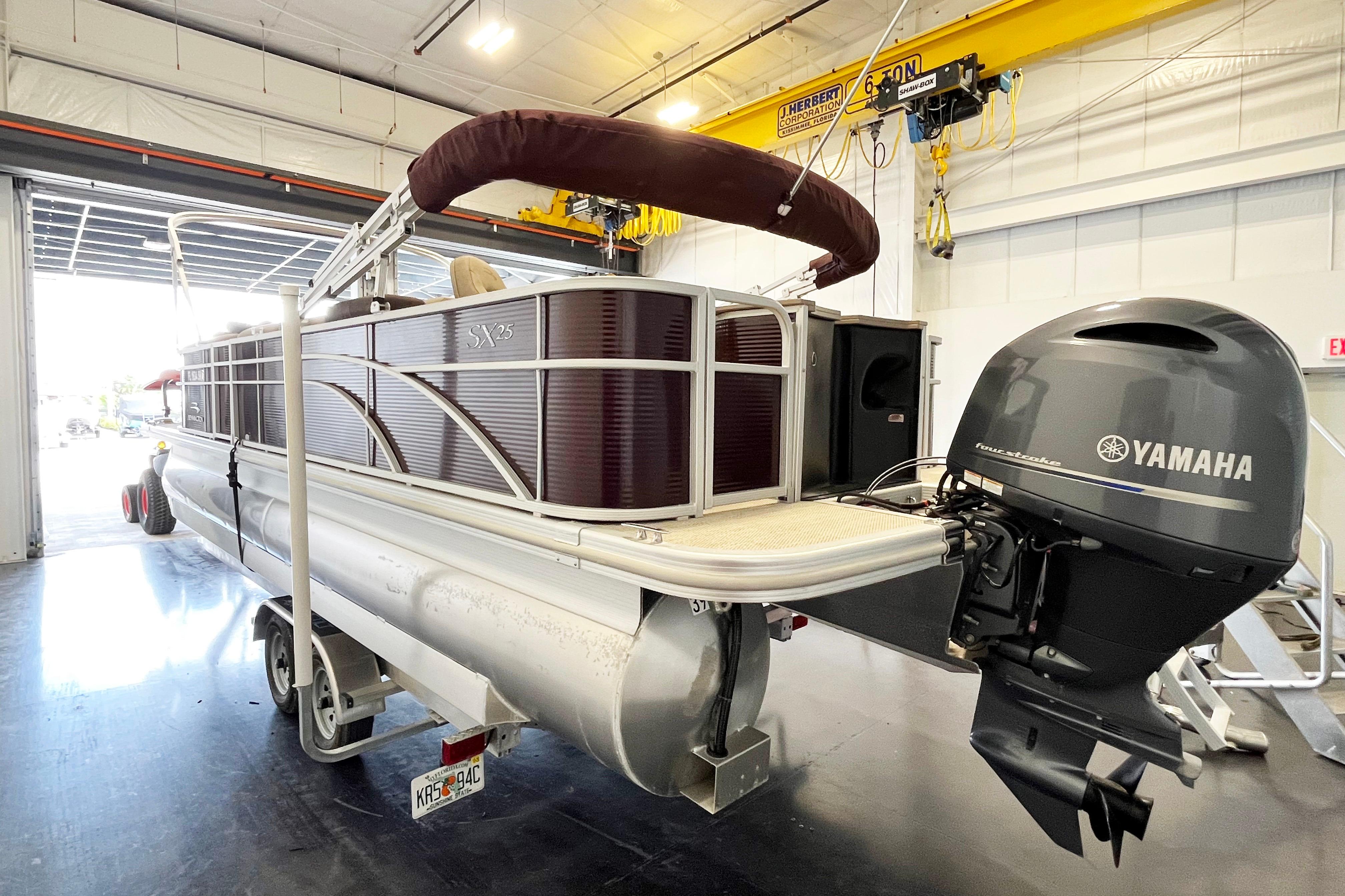 2020 Bennington SX25 pontoon boat with Yamaha outboard motor in a garage setting.