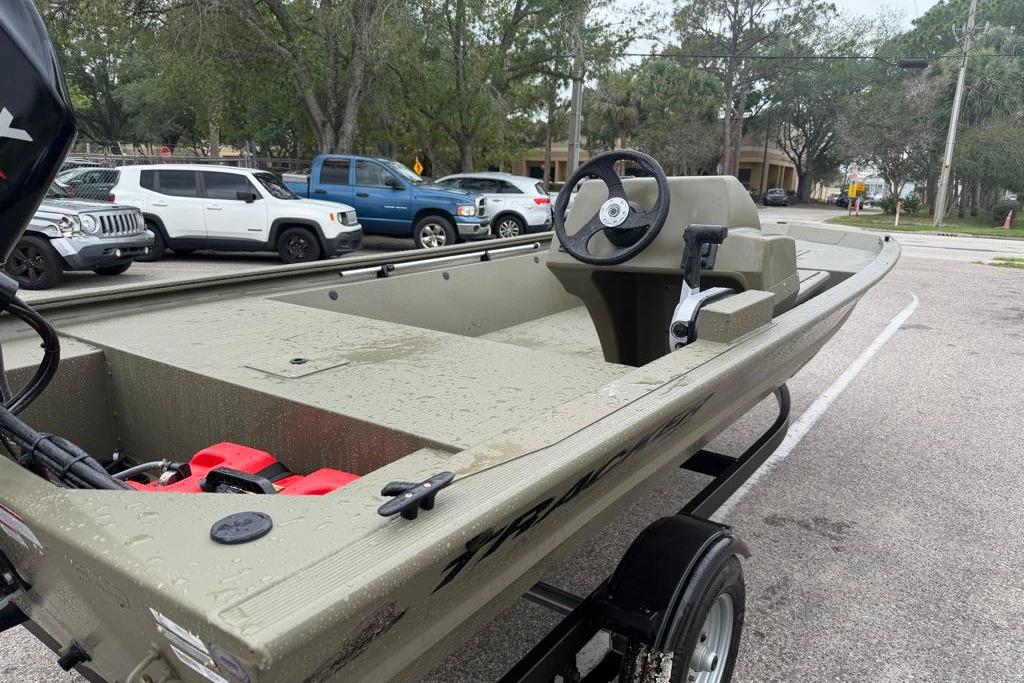 2026 Tracker Grizzly 1648 SC boat on trailer in parking lot, wet from rain.
