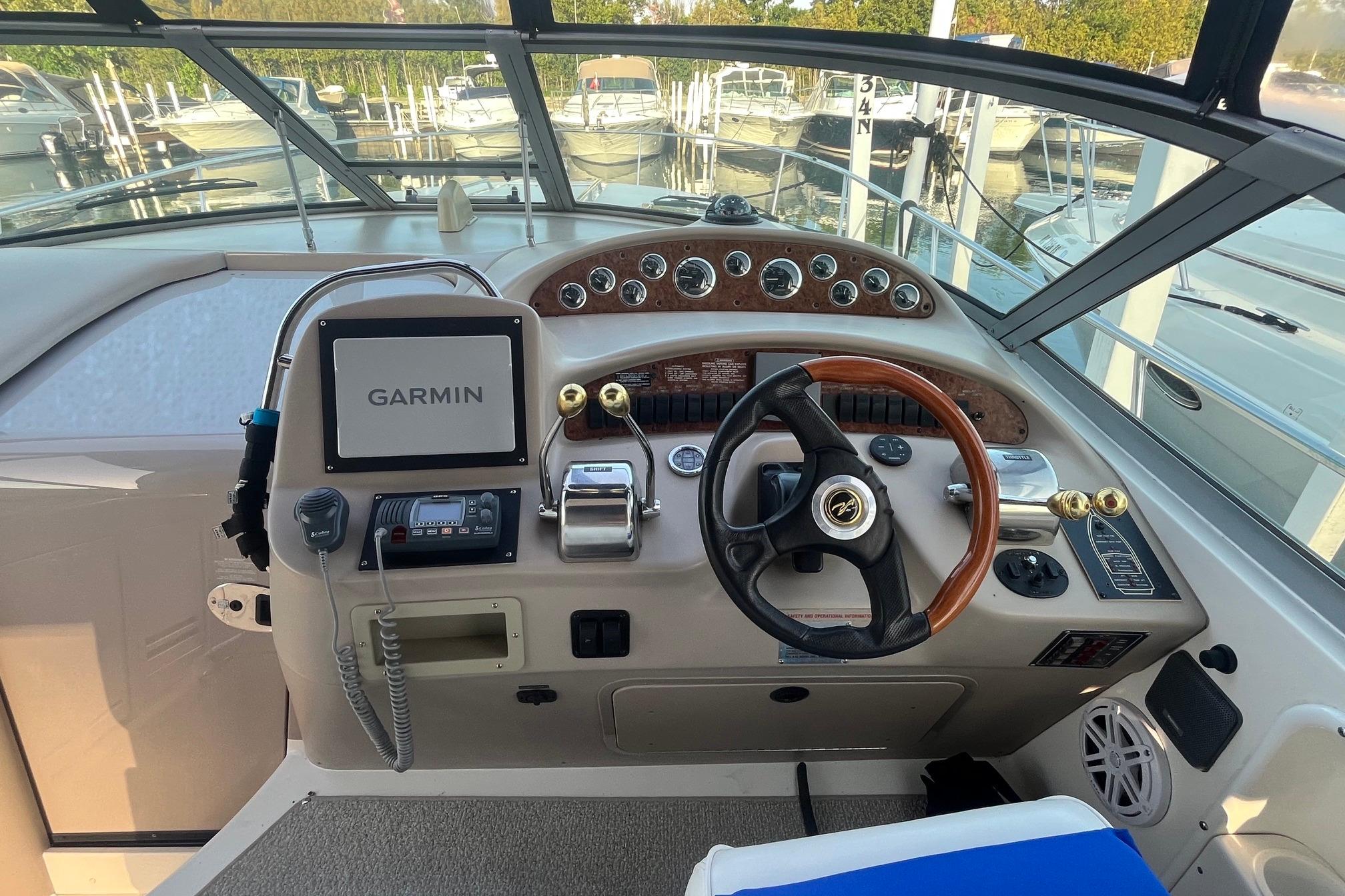 Cockpit of 2001 Sea Ray 340 Sundancer with Garmin navigation system and classic steering wheel.