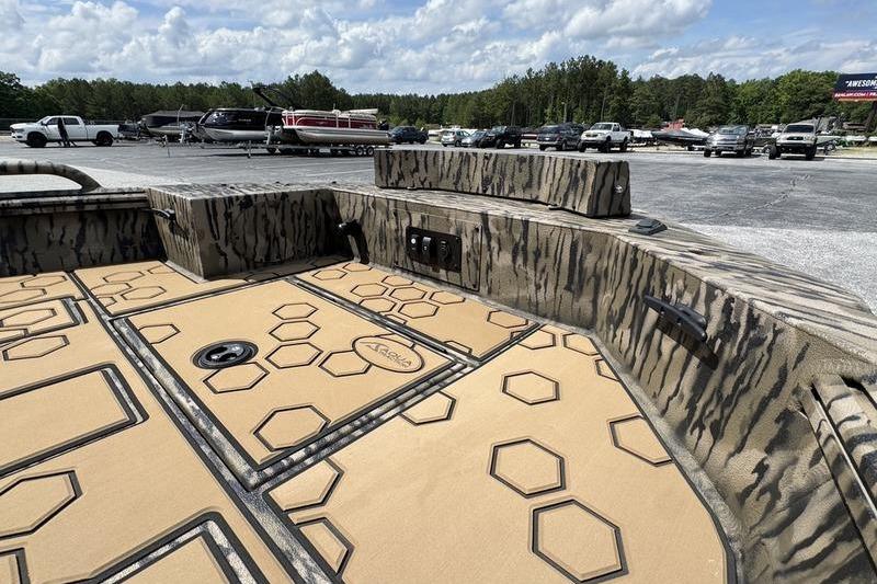 2026 Excel 183 Tomahawk boat interior with hexagonal pattern flooring, parked outdoors.