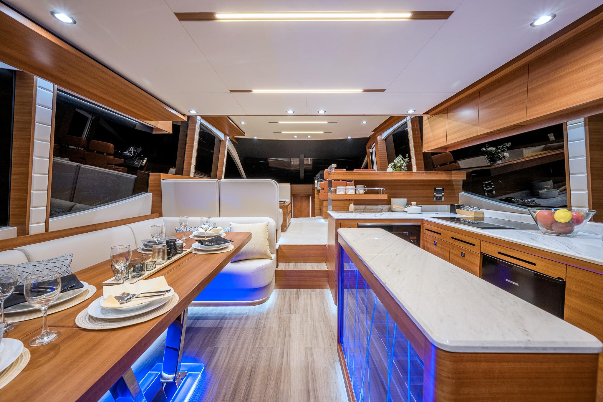 Luxurious interior of 2025 Dyna 63 yacht with modern dining and kitchen area.
