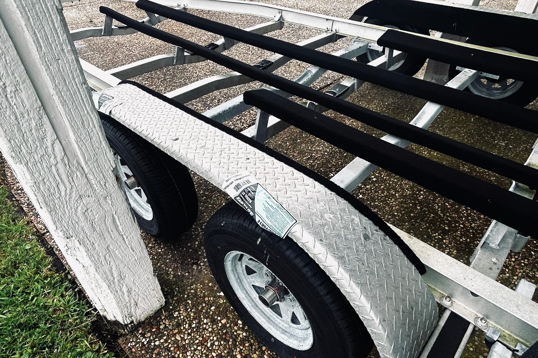 Trailer for 2017 Blue Wave 2200 PureBay boat, featuring dual wheels and metal frame.