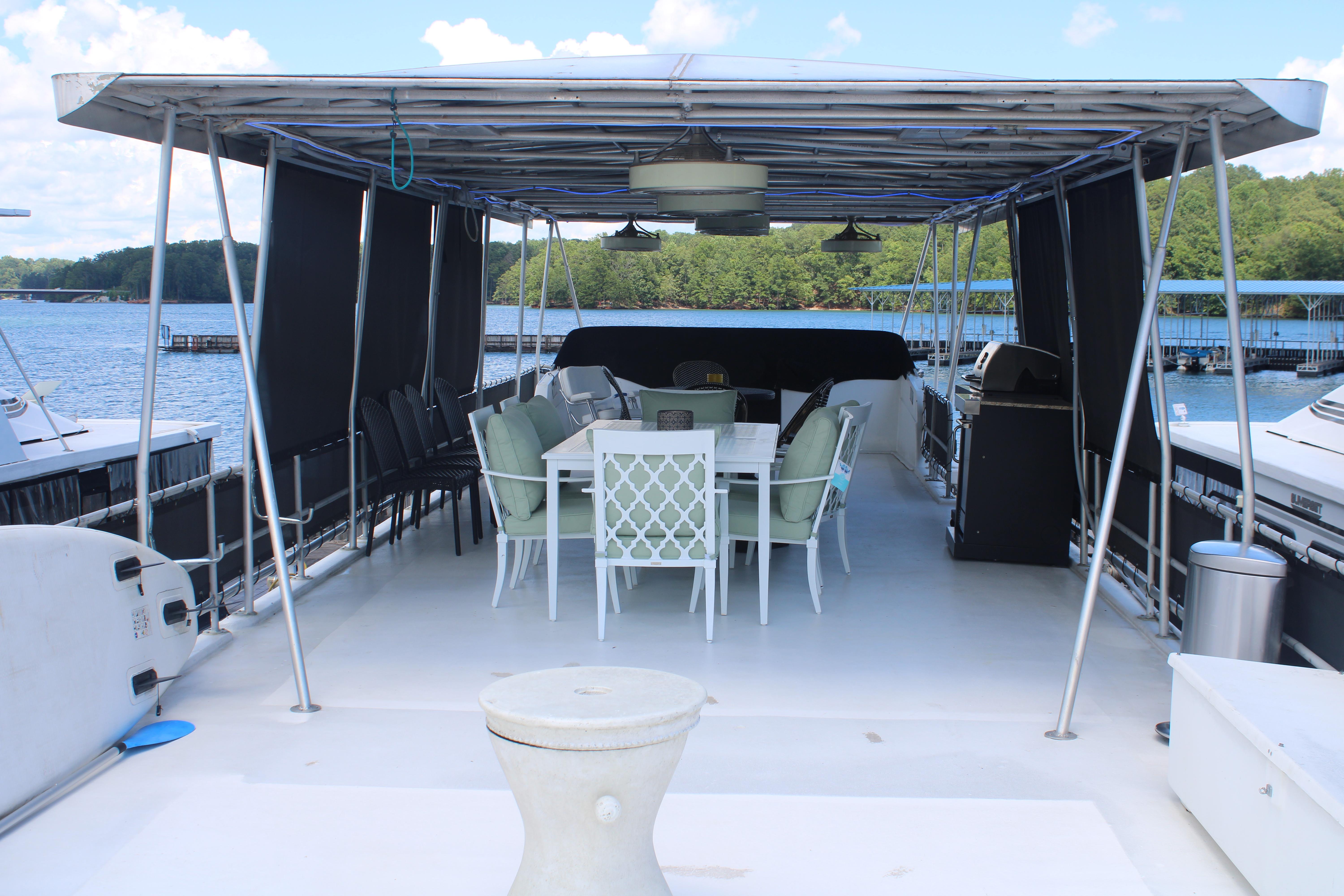 Covered deck of a 1992 Sumerset 66 houseboat with dining area and scenic lake view.