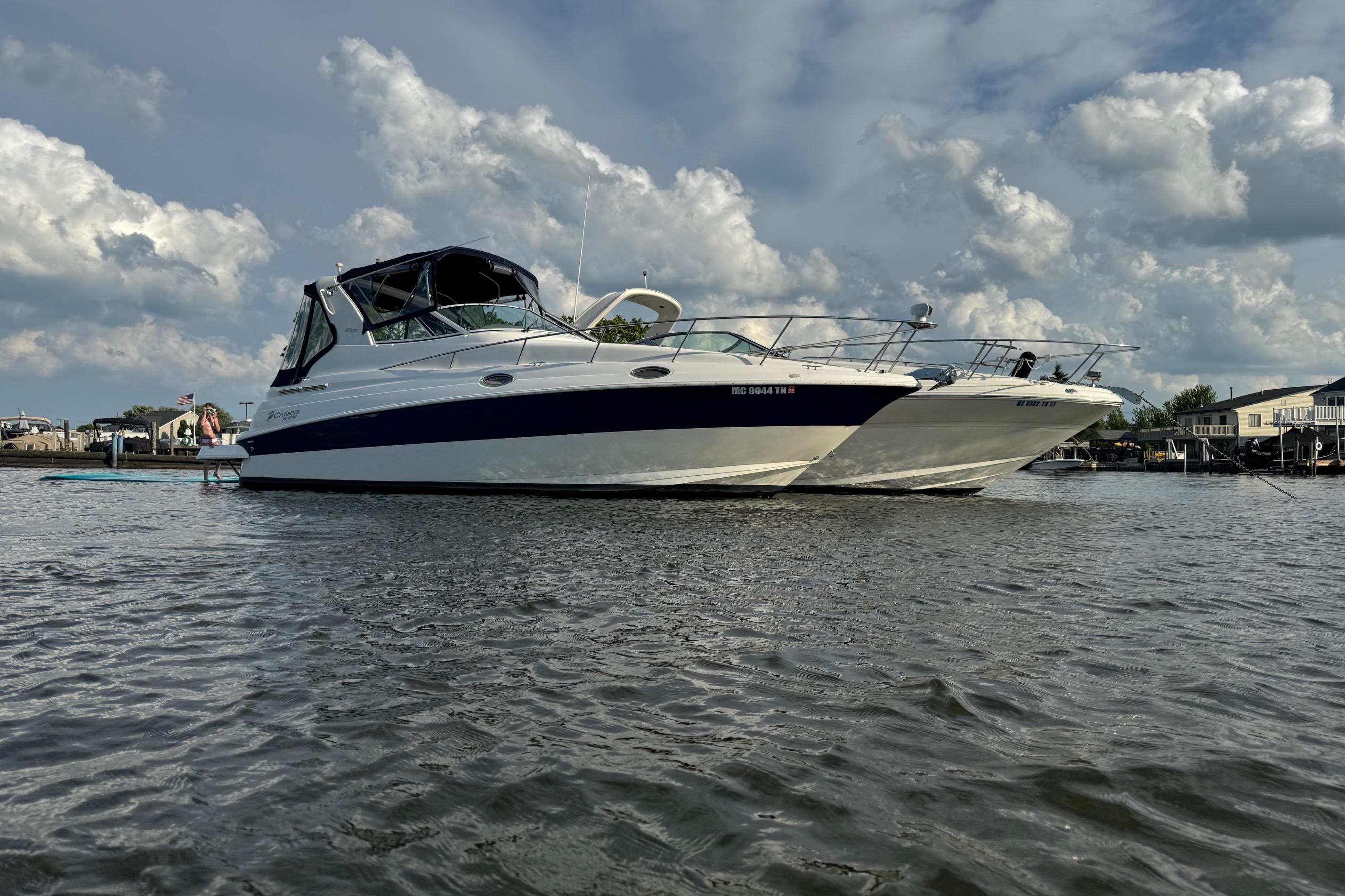 2004 Cruisers Yachts 280 CXi Express on calm water under cloudy sky.