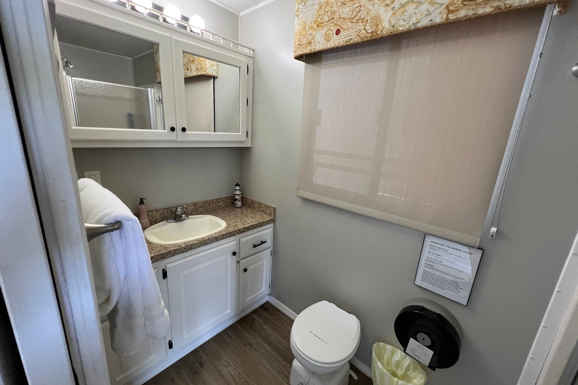 Compact bathroom in 1999 Aqua Chalet 4614 with sink, toilet, and storage cabinets.