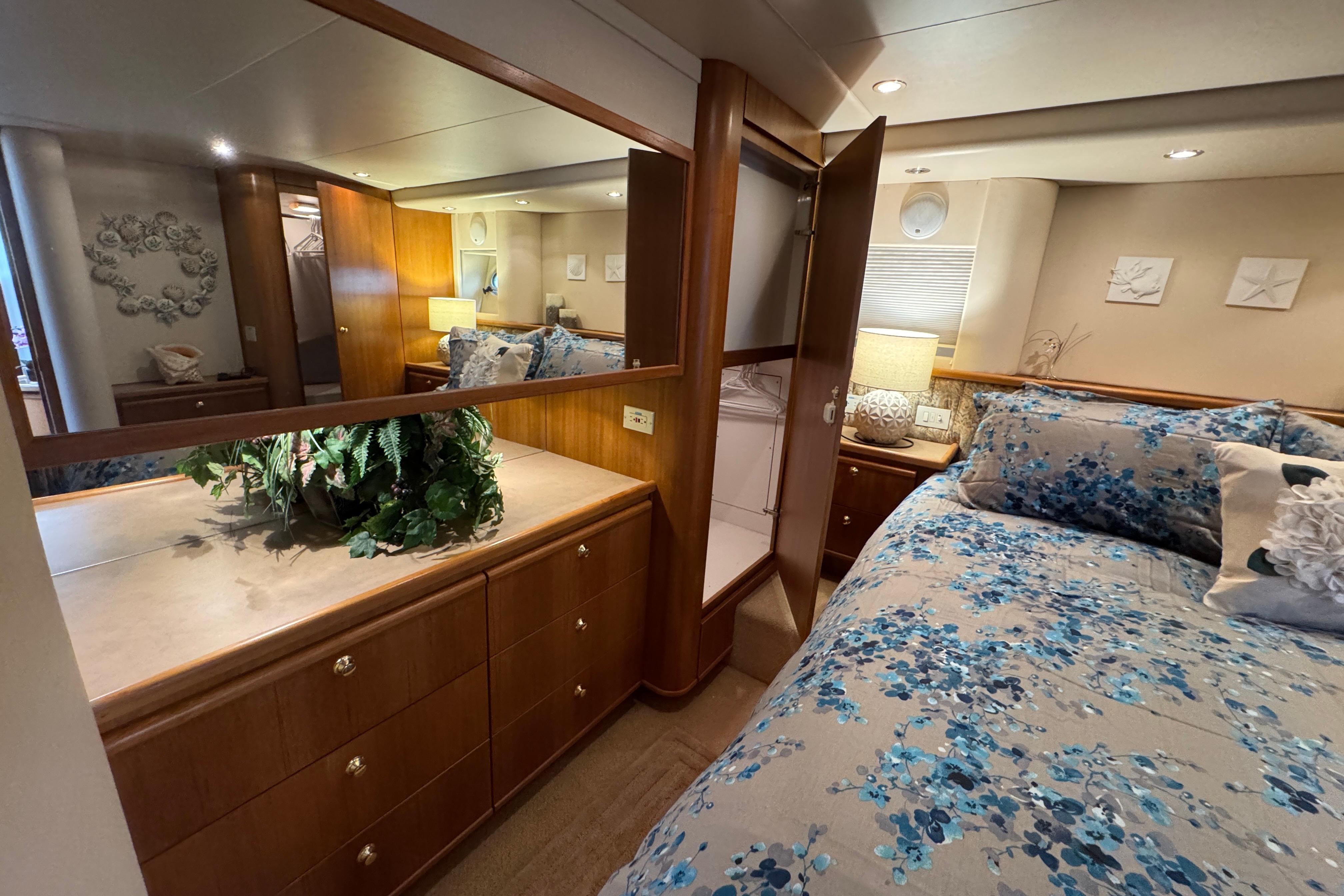 Luxurious bedroom interior of 1998 Bayliner 5788 Pilot House Motoryacht with floral bedding.