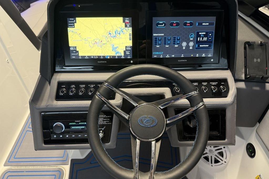 Steering wheel and dashboard of 2026 Cobalt R4 Surf boat with dual Garmin displays.