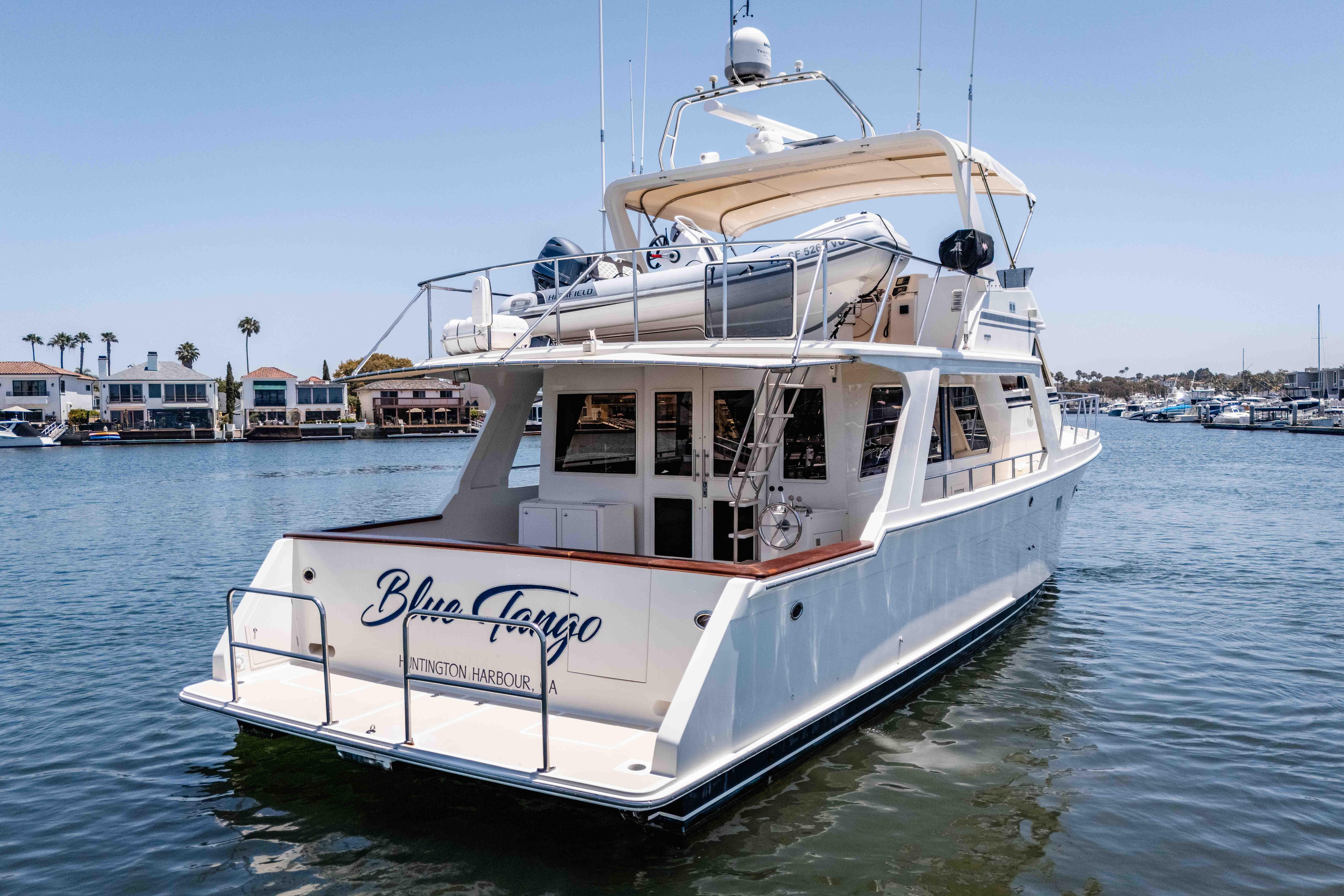 2005 Offshore Yachts 54 Pilothouse in marina, rear view with tender on deck.