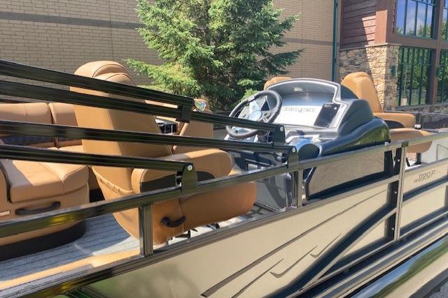 2026 Ranger 220F pontoon boat with tan seating and modern dashboard, outdoors.