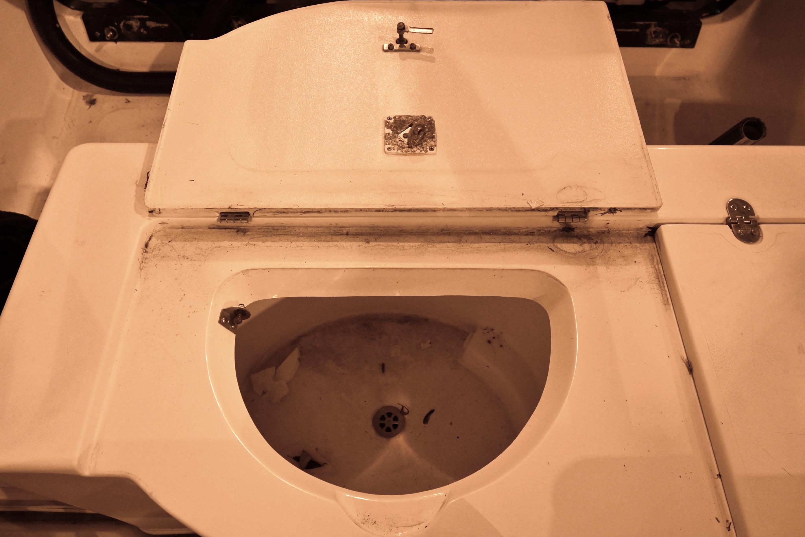 2001 Fountain 38 Center Console boat sink with closed lid, showing wear and dirt.