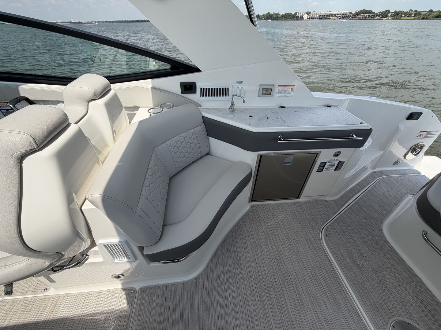 Interior of 2026 Sea Ray Sundancer 320 Outboard with seating and kitchenette.