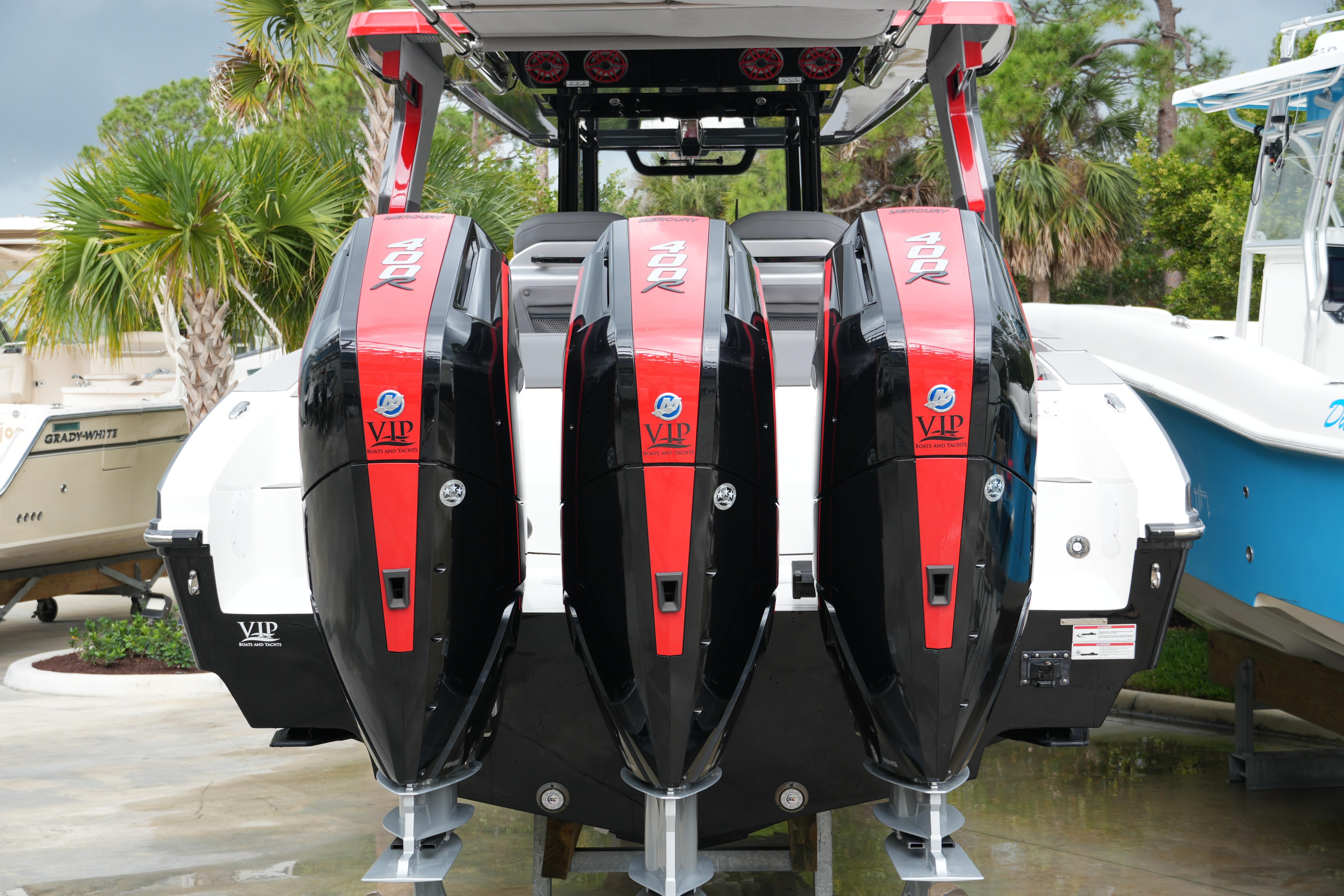 2025 Fountain 38 SCX boat with triple 400R outboard engines, docked near palm trees.