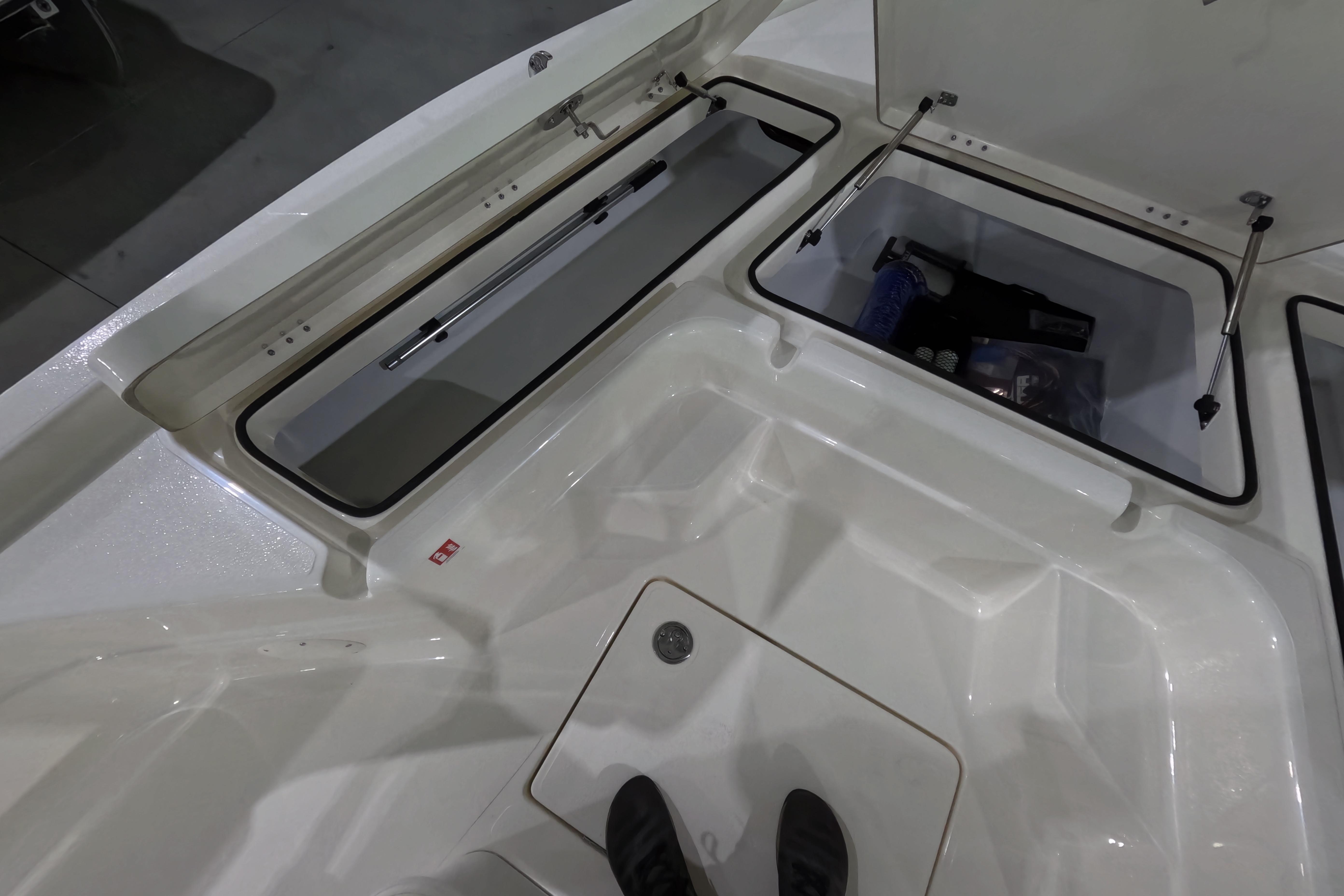 2026 Skeeter SX221 boat storage compartments with open lids and visible gear inside.