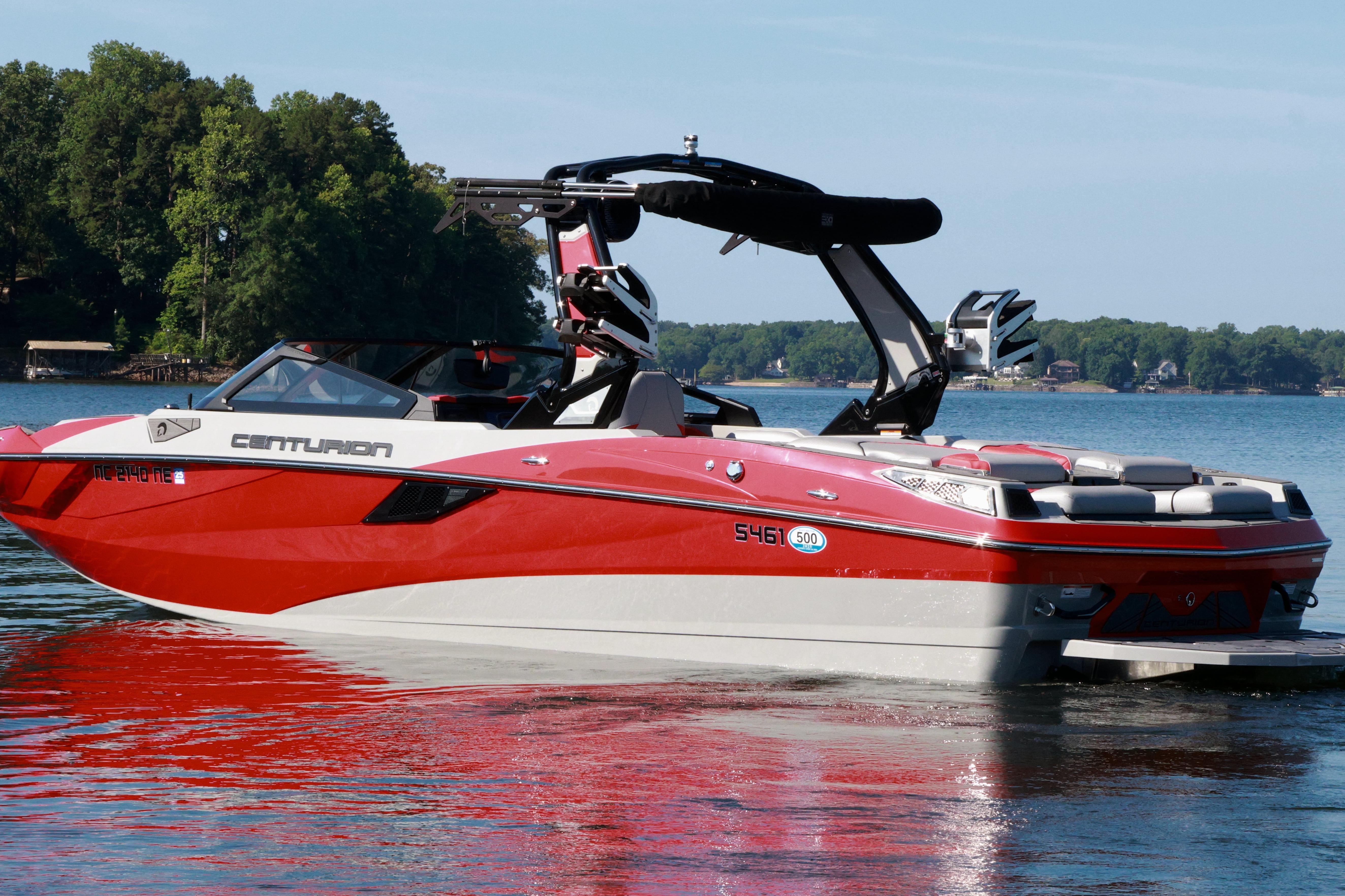 2024 Centurion Fi23 boat in red and white on a serene lake.