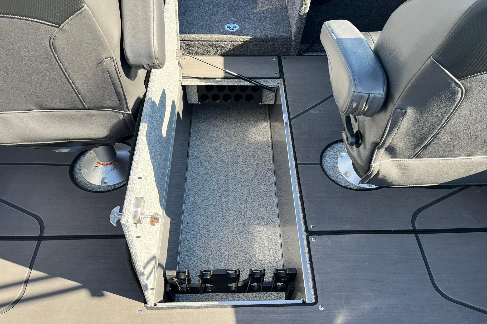 2026 Lund 2275 Baron boat interior with open storage compartment between seats.