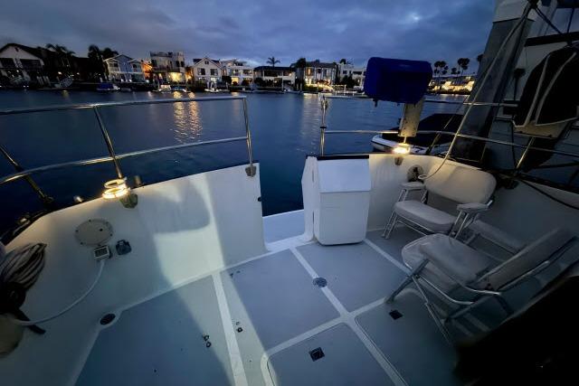 Cockpit view of 1982 Lancer 45 Motorsailer at dusk, overlooking serene waterfront homes.
