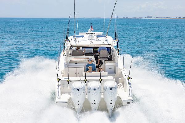 2025 Pursuit OS 405 boat cruising on open water with triple engines.