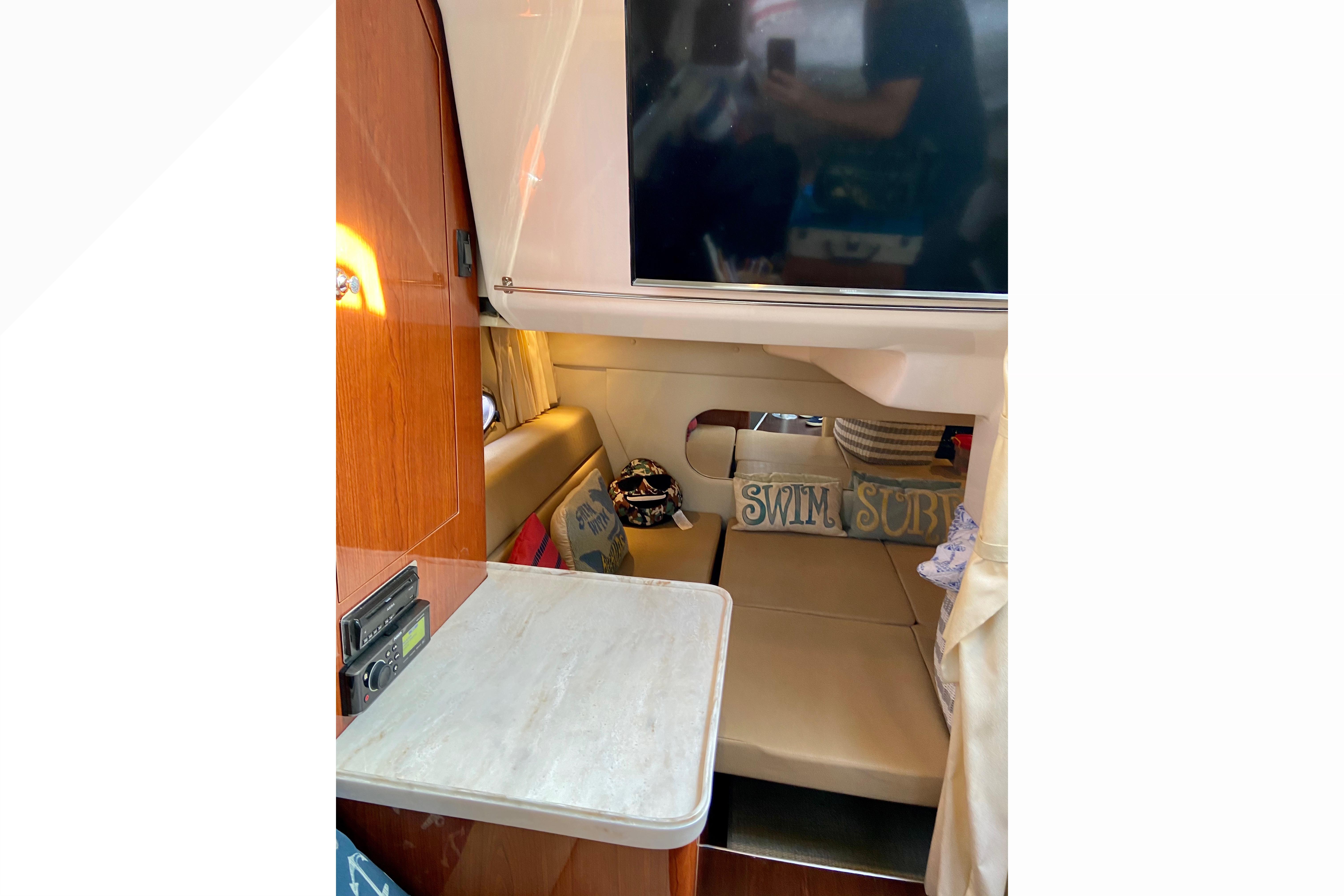 Interior of 2012 Regal 35 Express Cruiser with cozy seating and decorative pillows.