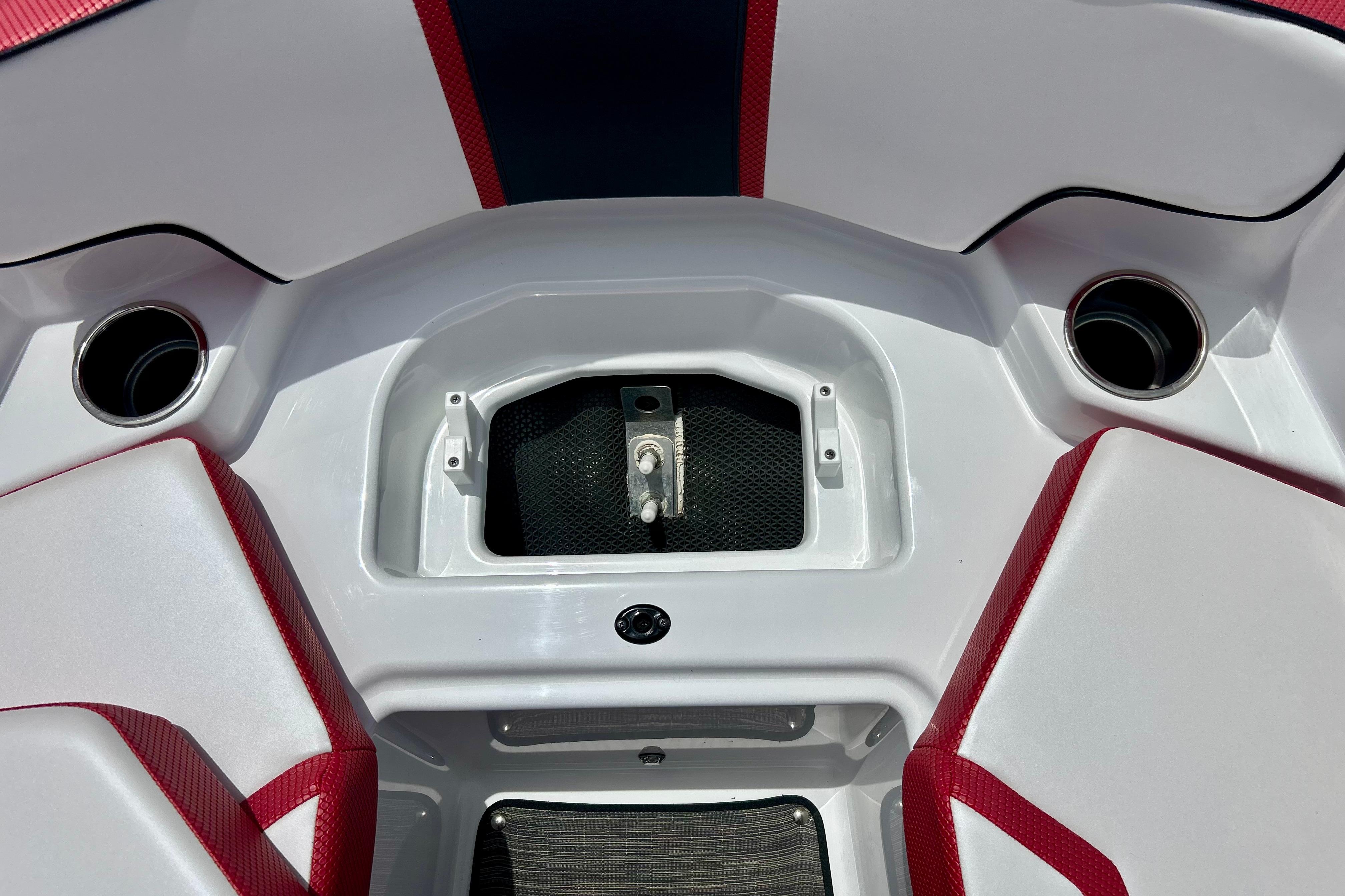 Interior of 2021 Scarab 195 ID boat with red and white seating and storage compartment.